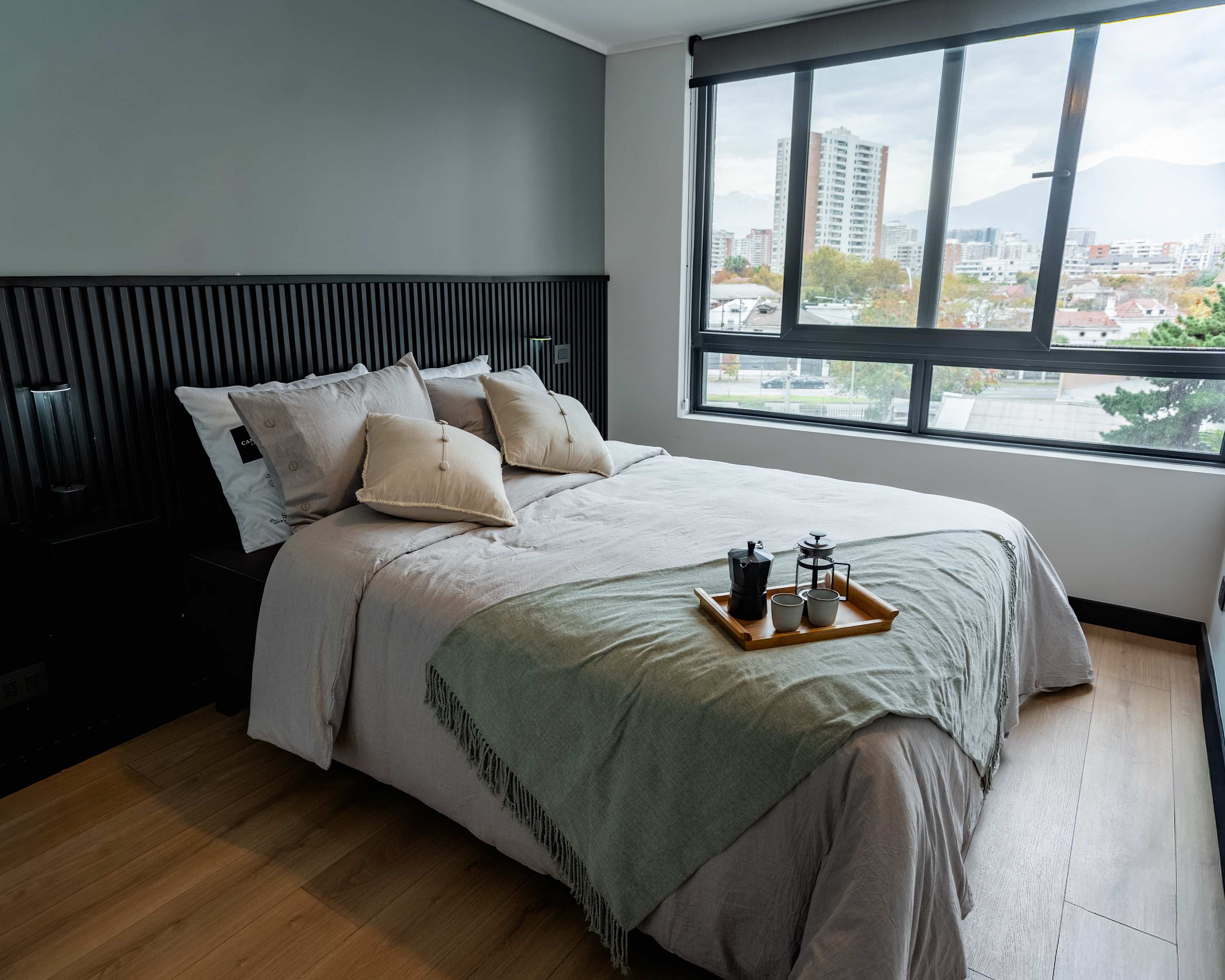 Relax in this stylish bedroom with stunning city views and cozy amenities.