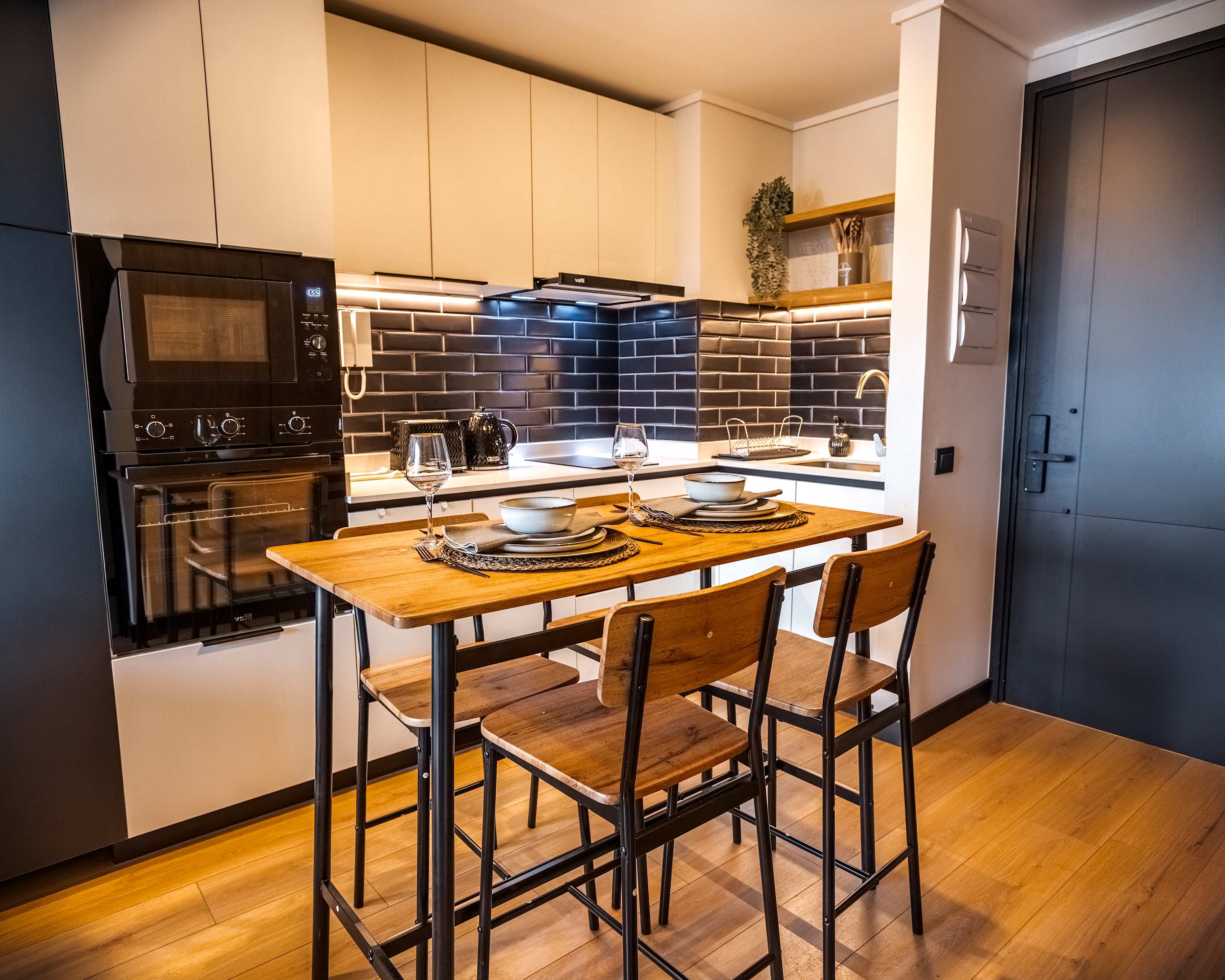 Modern kitchen with sleek design and cozy dining area, perfect for intimate meals.