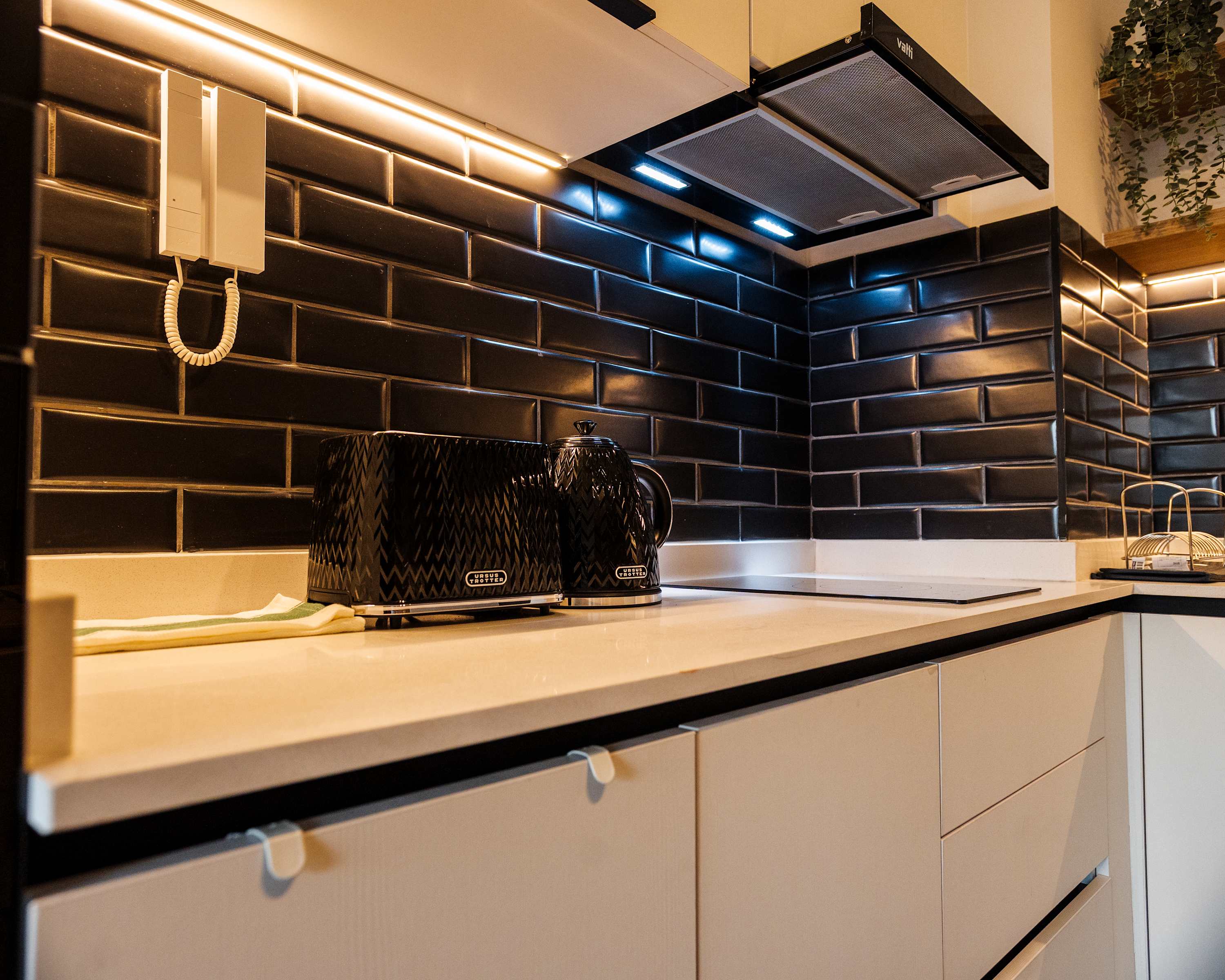 Sleek and modern kitchen with stylish black backsplash and appliances, perfect for cooking your favorite meals.