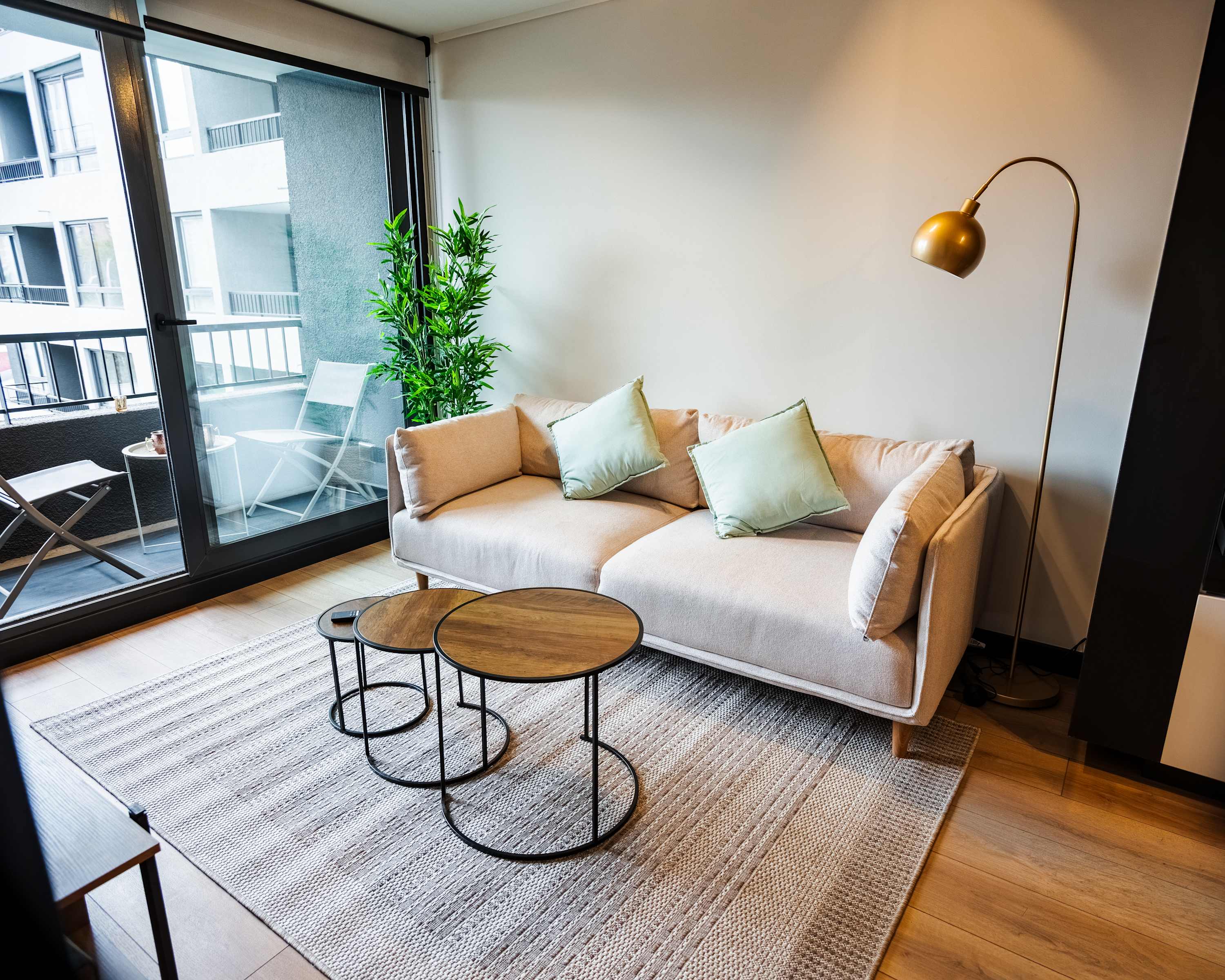 Unwind in this chic living room with a cozy sofa and sunny balcony, perfect for relaxation after exploring the city.