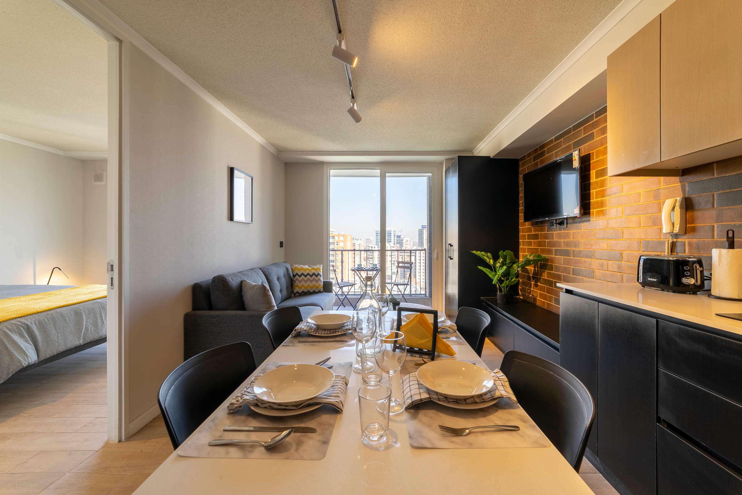Enjoy city views from this stylish apartment featuring a cozy living area, modern kitchen, and inviting dining space.