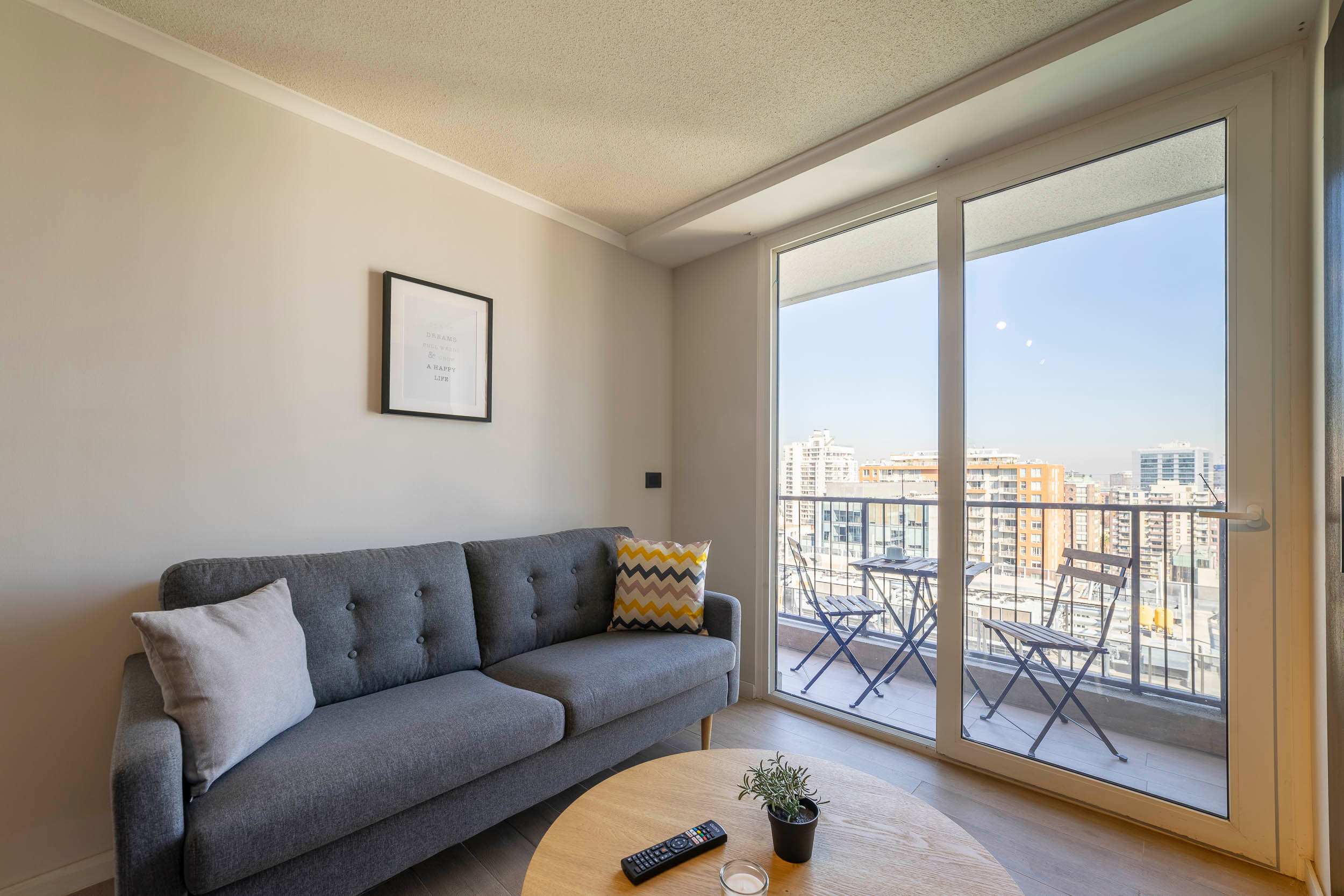 Relax in this cozy living room with a stunning city view from the balcony, perfect for enjoying a morning coffee.
