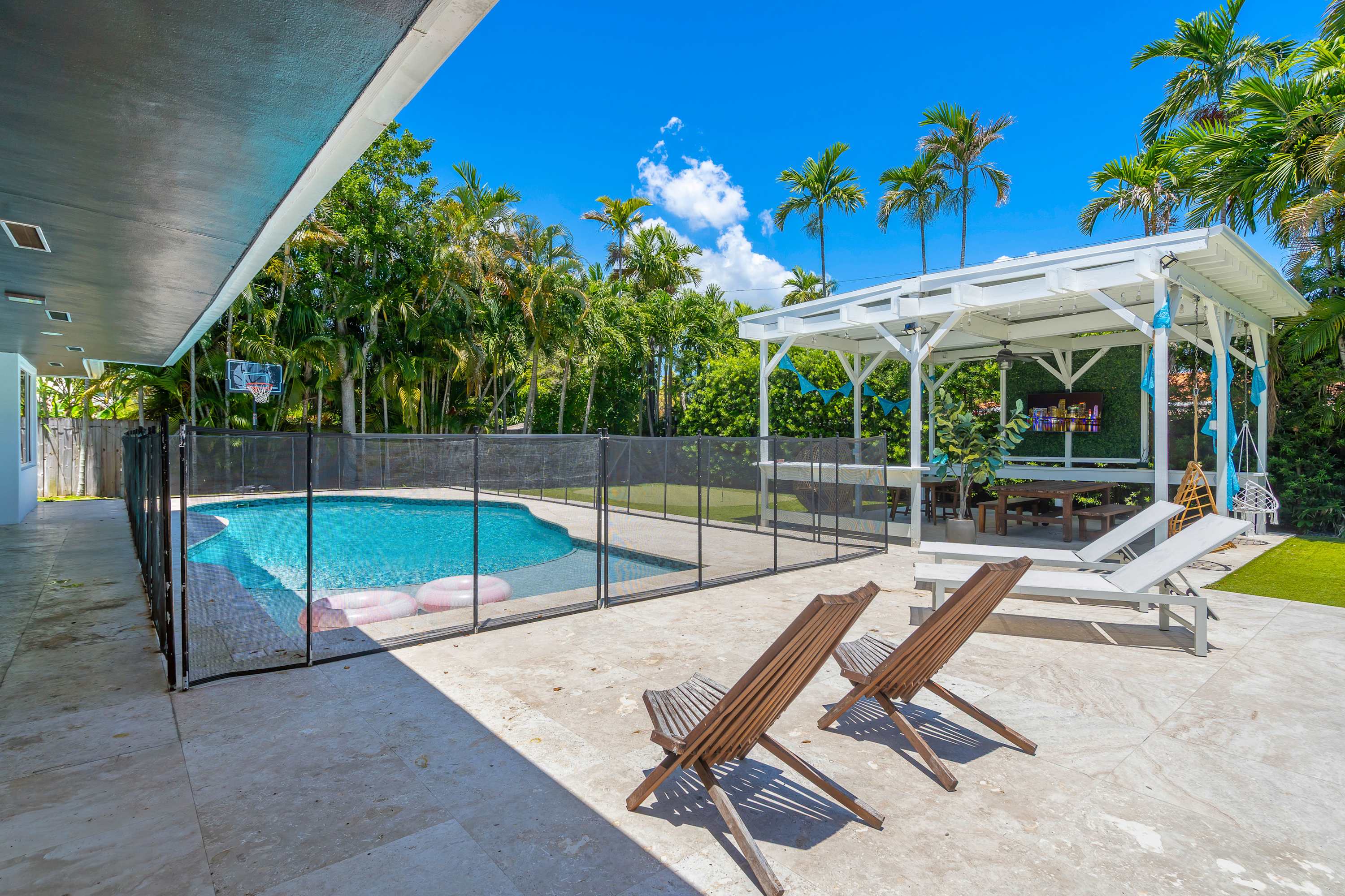 The back yard oasis boasts a private pool, putting green, lounge space, & more!​