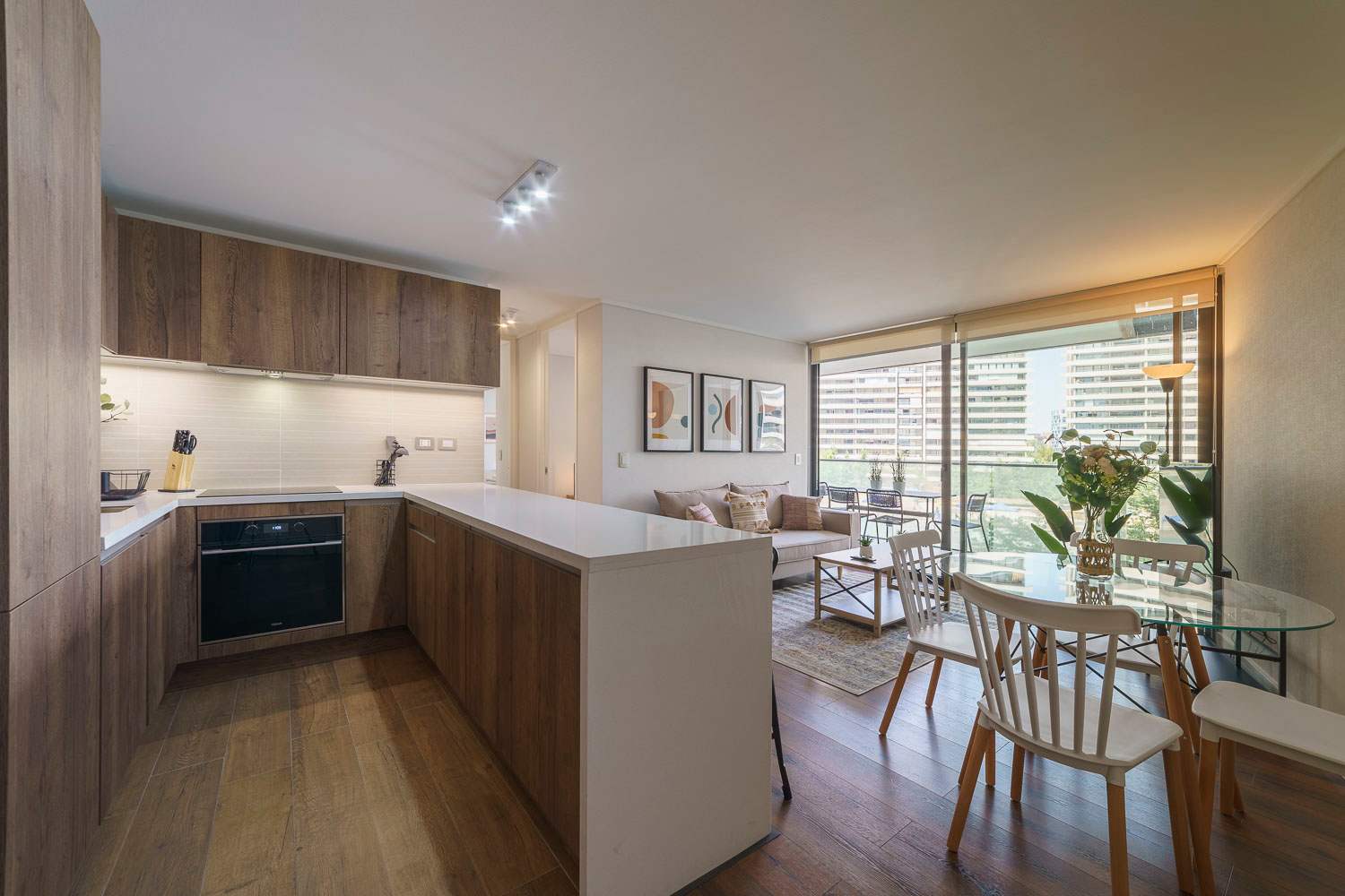 Modern kitchen and cozy living area with stunning city views, perfect for a relaxing stay.