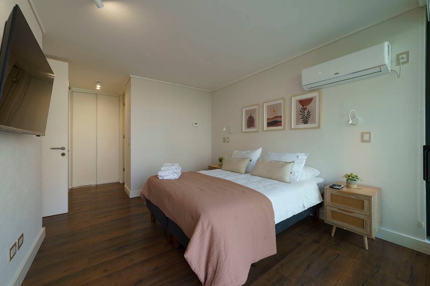 Relax in this cozy bedroom with modern decor, plush bedding, and a smart TV for your entertainment.