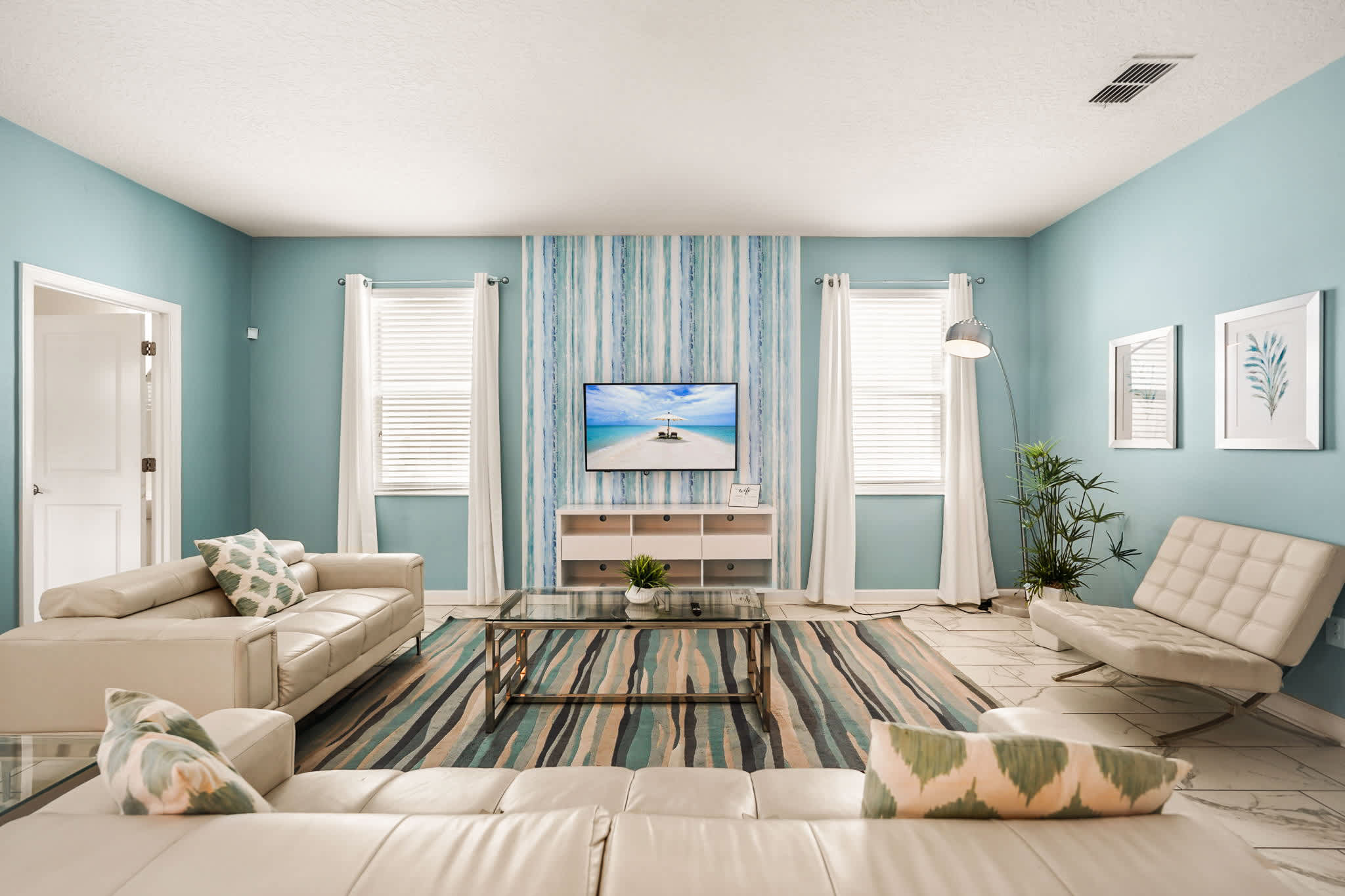 Relax in this stylish living room with modern decor and a calming blue palette, perfect for unwinding after a day of adventure.