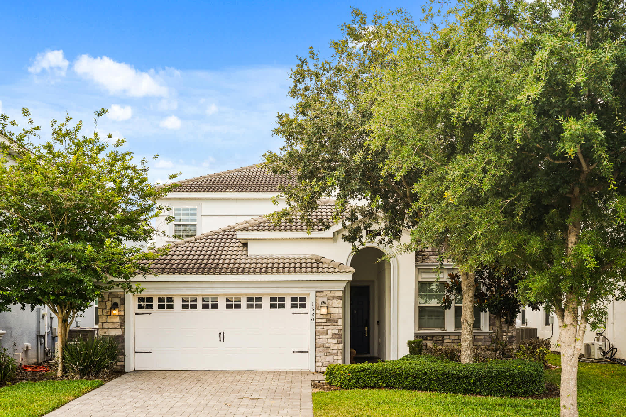 Spacious villa with a charming exterior and lush greenery, perfect for a relaxing getaway.