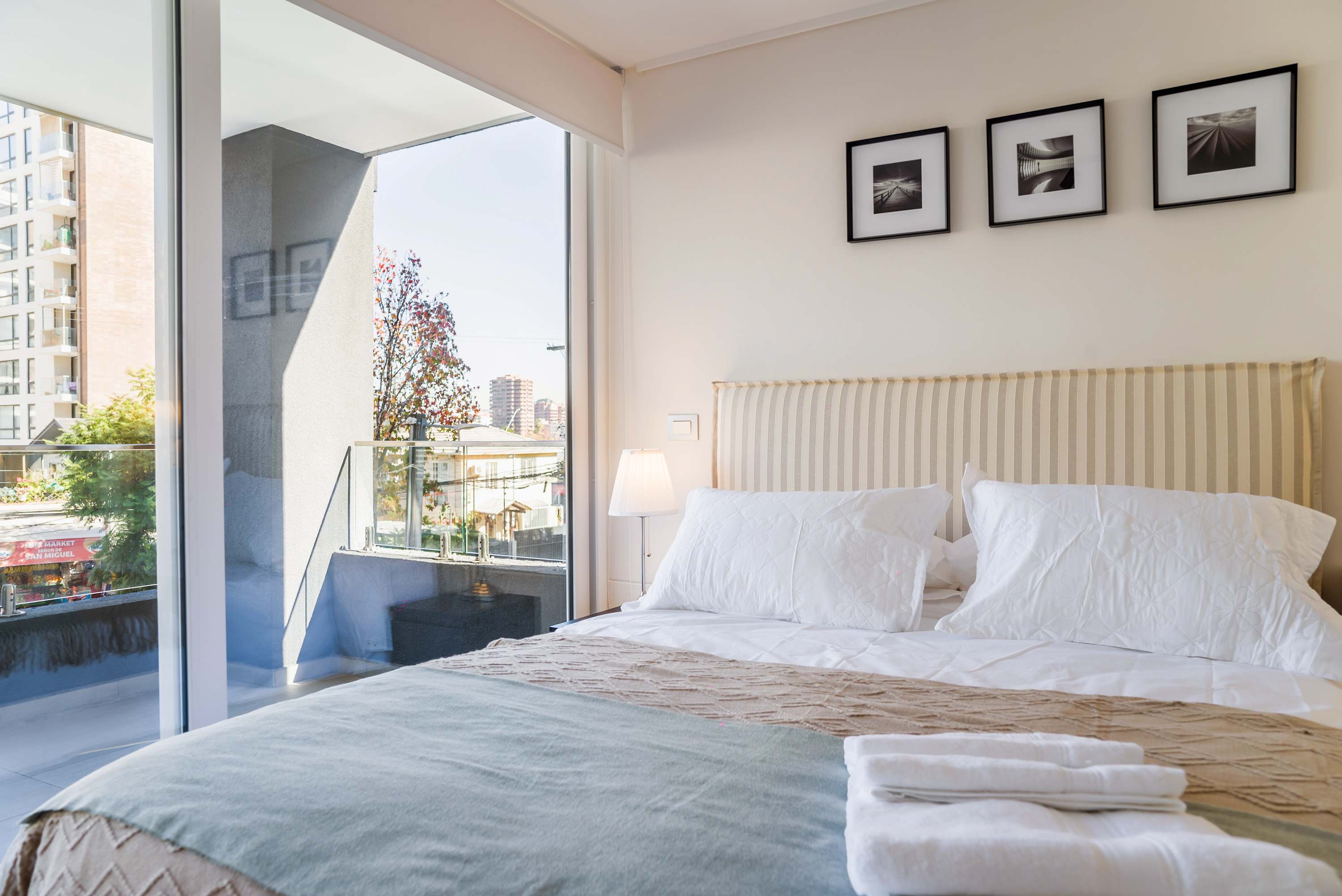 Relax in this cozy bedroom with a stunning city view and private balcony access.