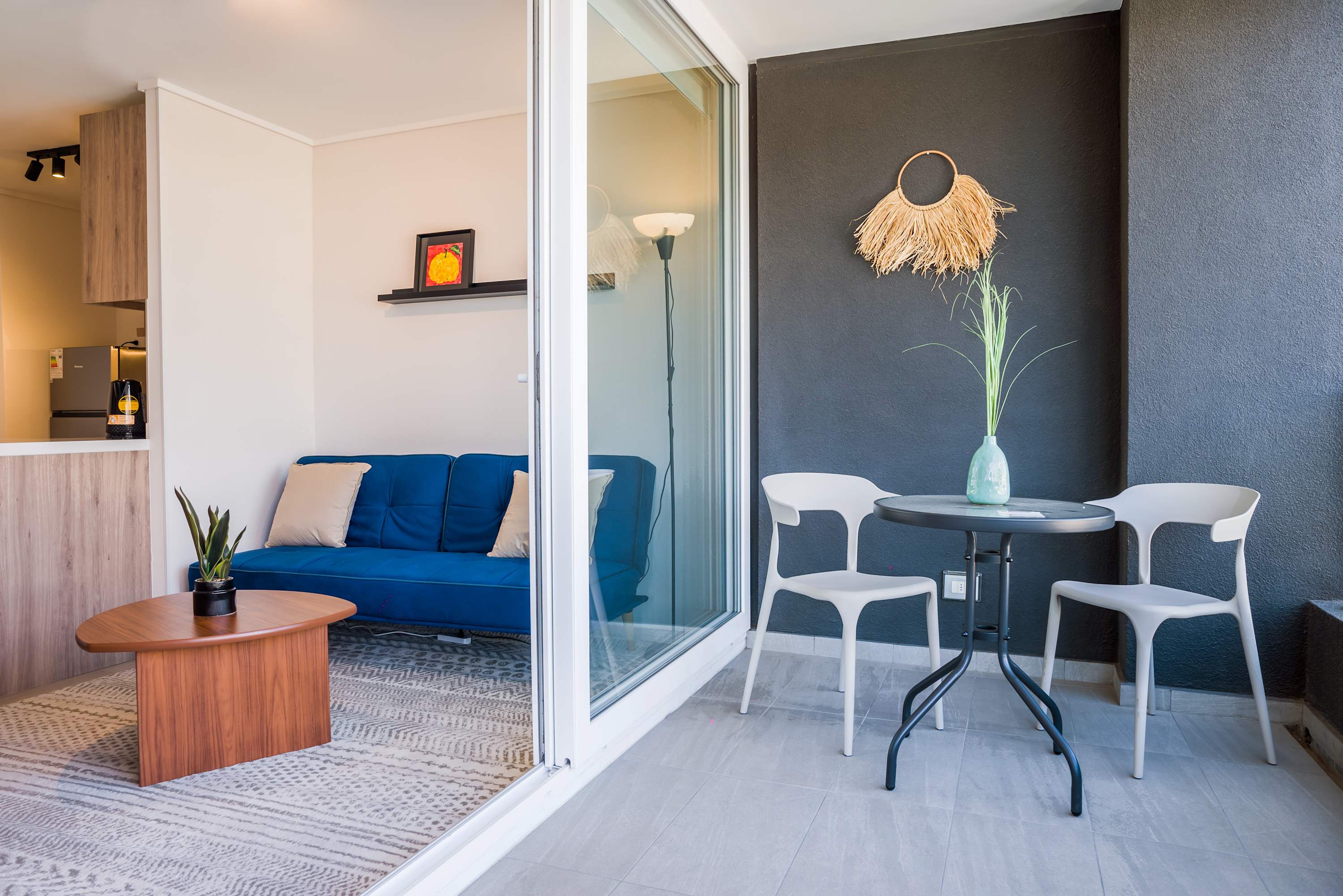 Relax on your private balcony with stylish seating and enjoy seamless indoor-outdoor living in this cozy studio apartment.