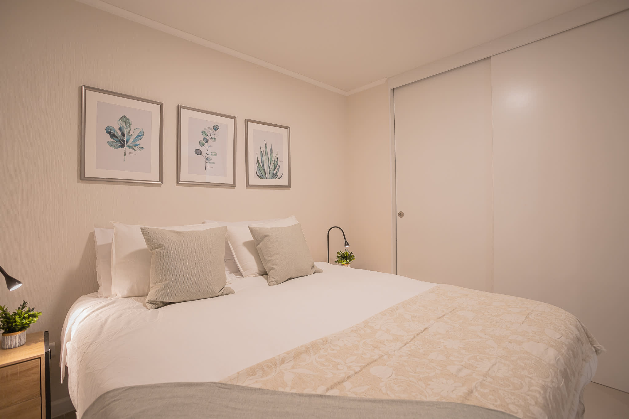 Relax in this cozy bedroom with elegant decor and soothing botanical art, perfect for a restful stay.