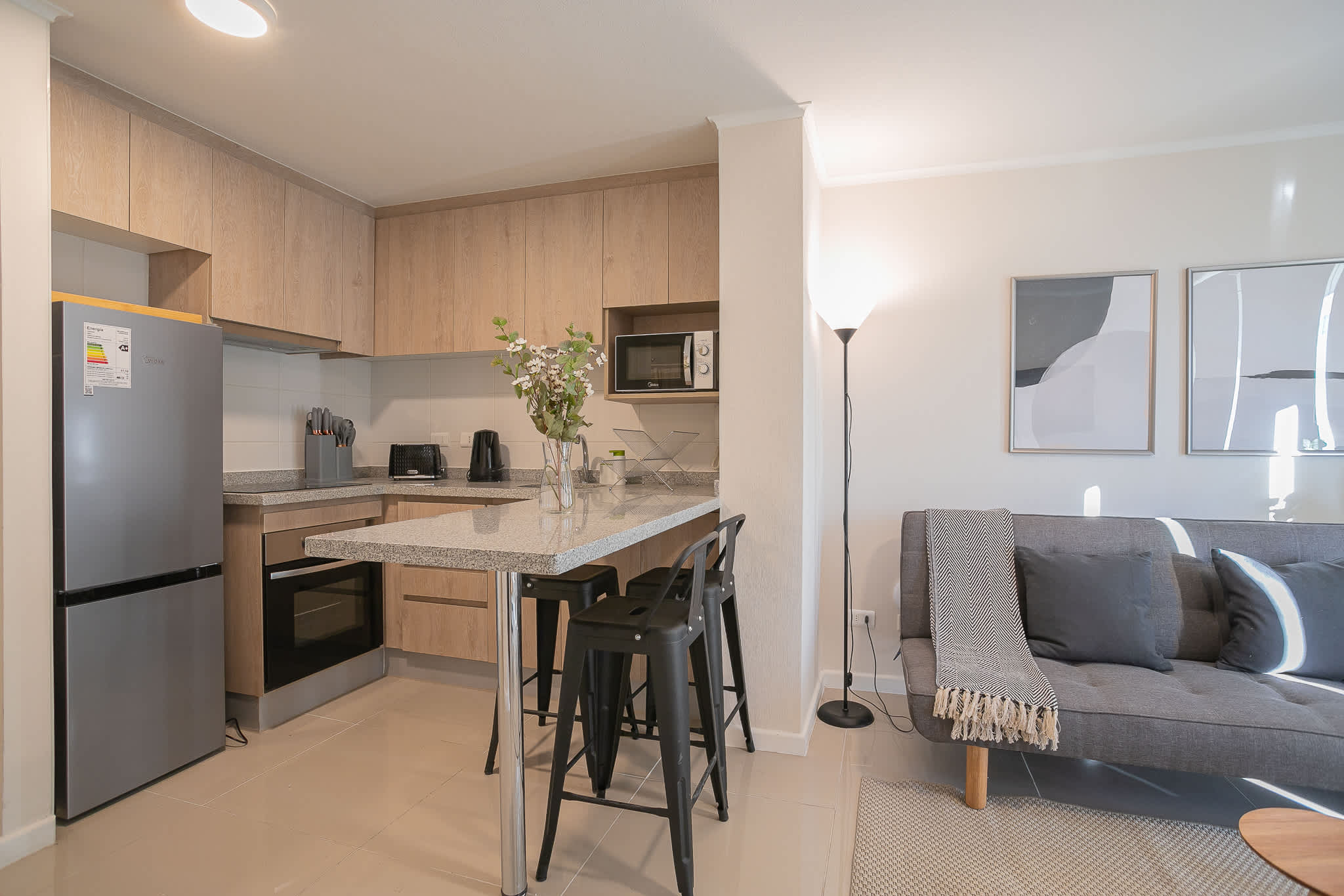 Modern studio kitchen with sleek appliances and cozy seating, perfect for a comfortable stay in the heart of Chile.