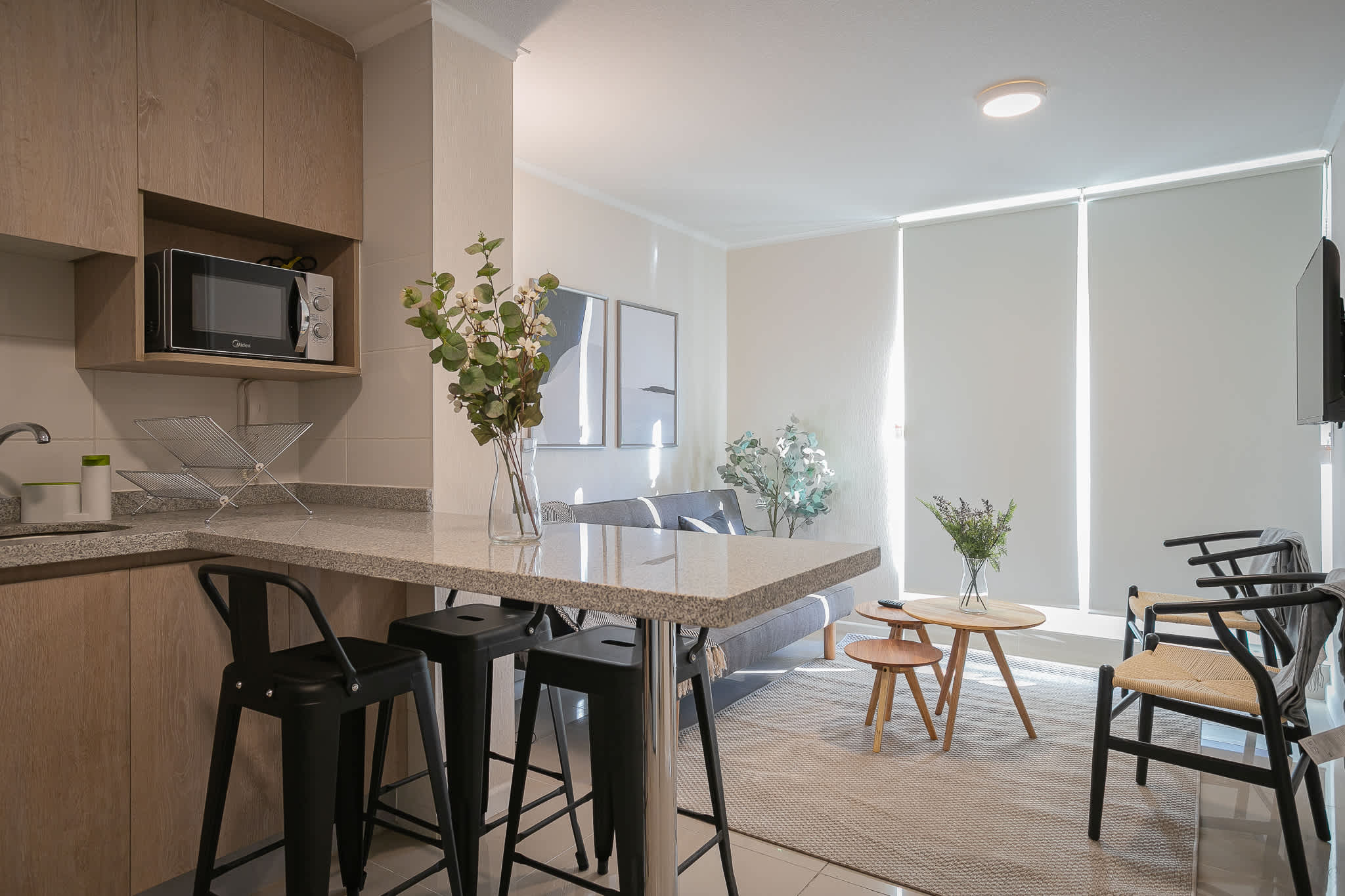 Cozy and modern living space with a kitchenette and stylish decor, perfect for relaxing after exploring the city.