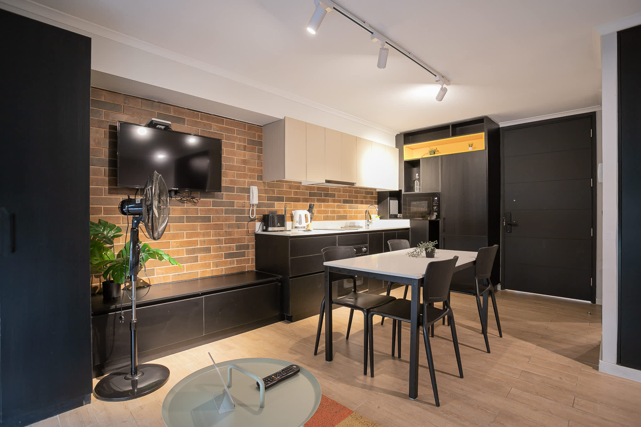Modern kitchen with stylish brick accents and dining area, perfect for cozy meals in a chic setting.