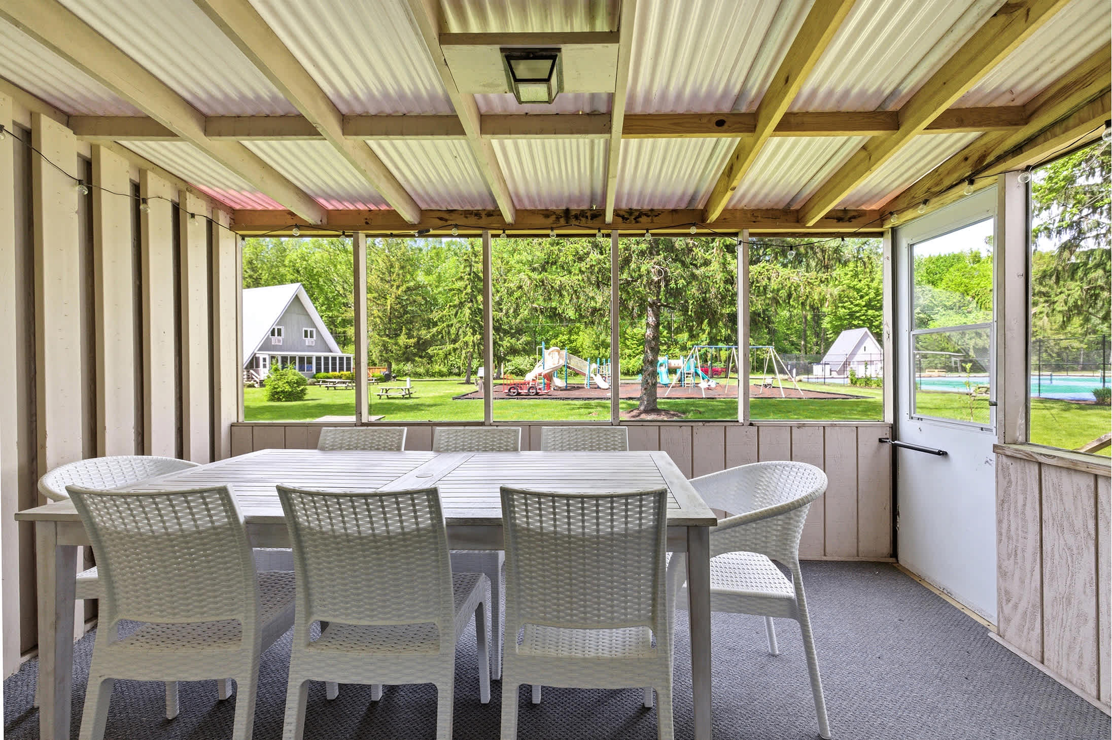 Enjoy dinner on the screened porch while the kids play at Chalet on the Lake's playground.