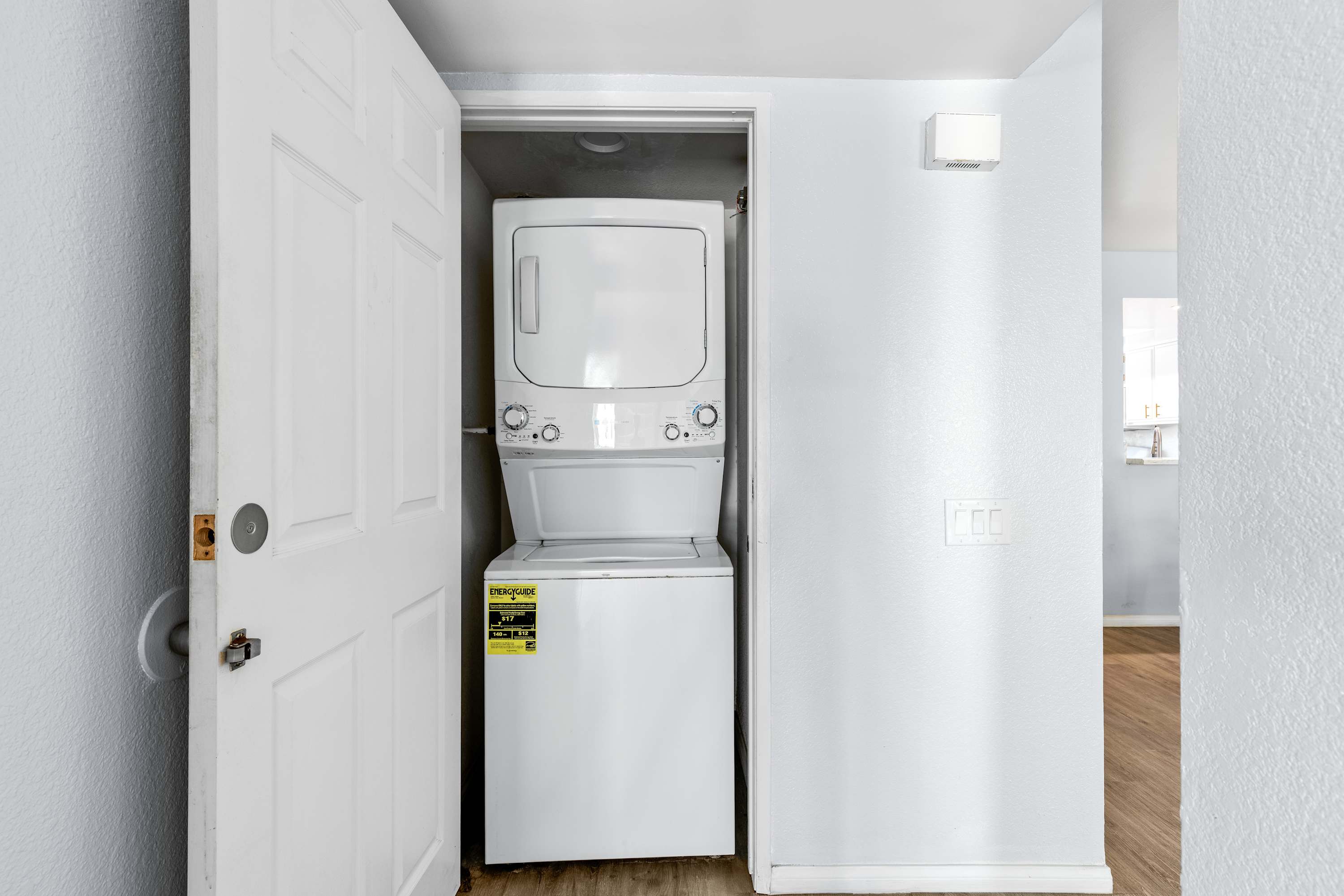 Laundry closet with a stacked washer and dryer.