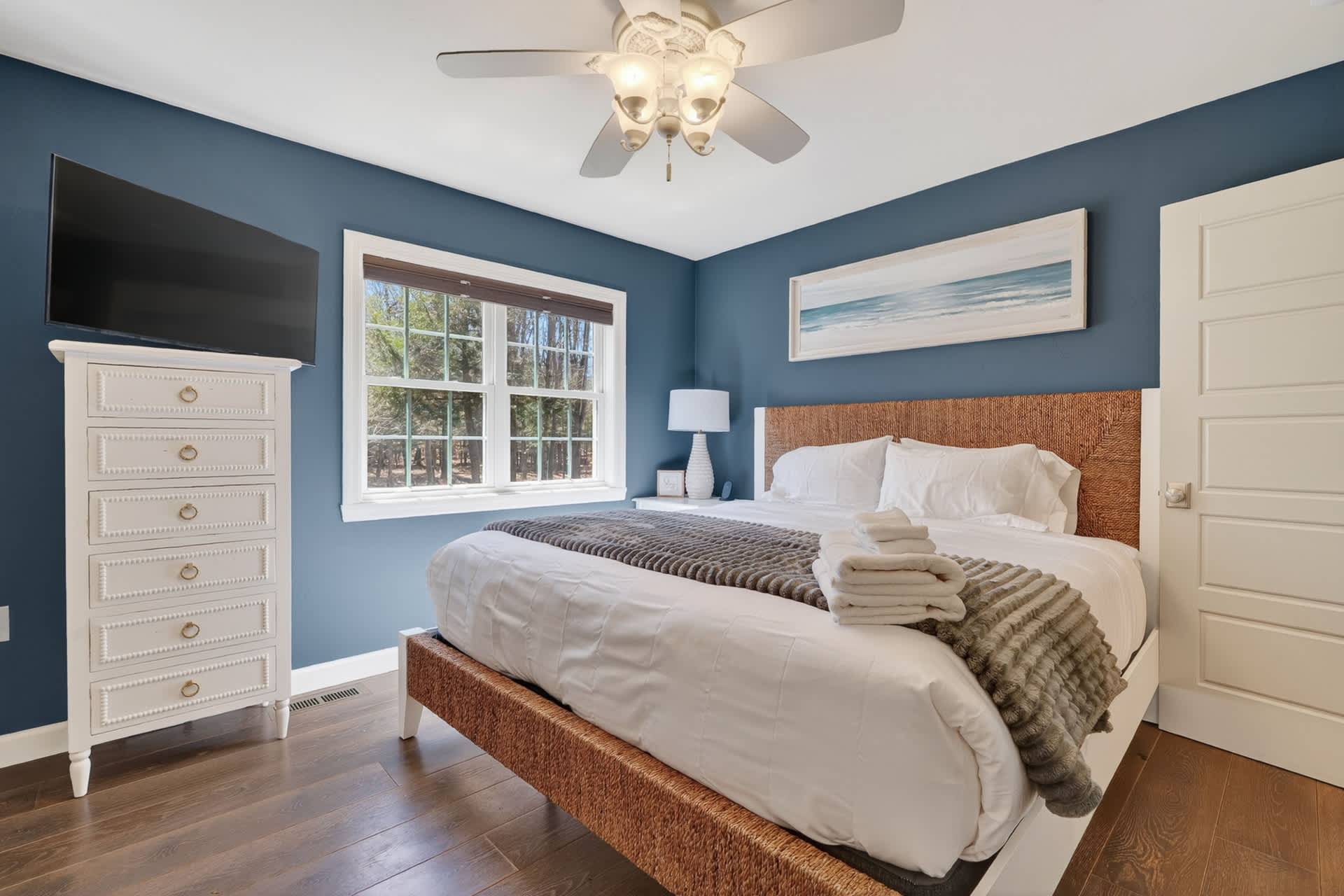 Relax in this tranquil King bed with soothing blue walls, crisp white linens, and coastal artwork that invites peaceful dreams.