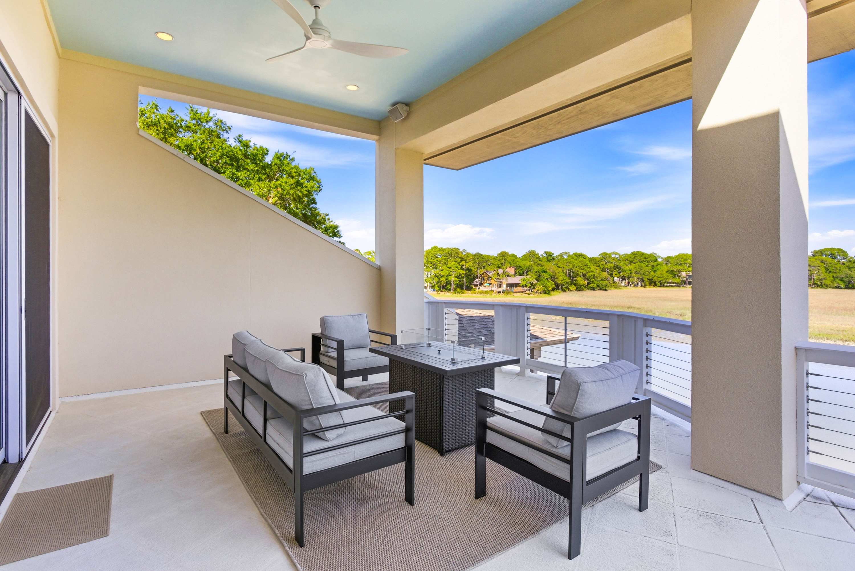 Covered upper terrace with ceiling fan, fire pit, and open water views — undeniably the best seat in the house.