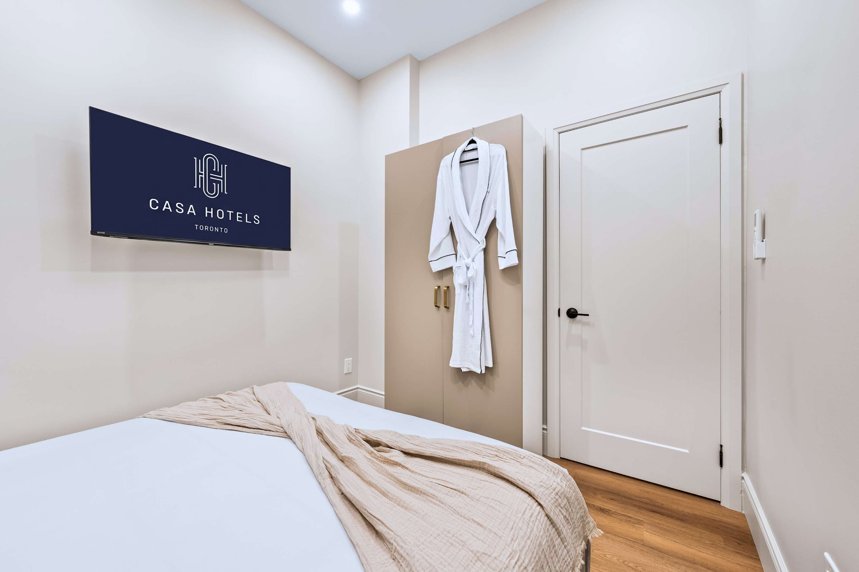 Queen bedroom with smart TV, robes, and storage cabinet for a comfortable, easy stay