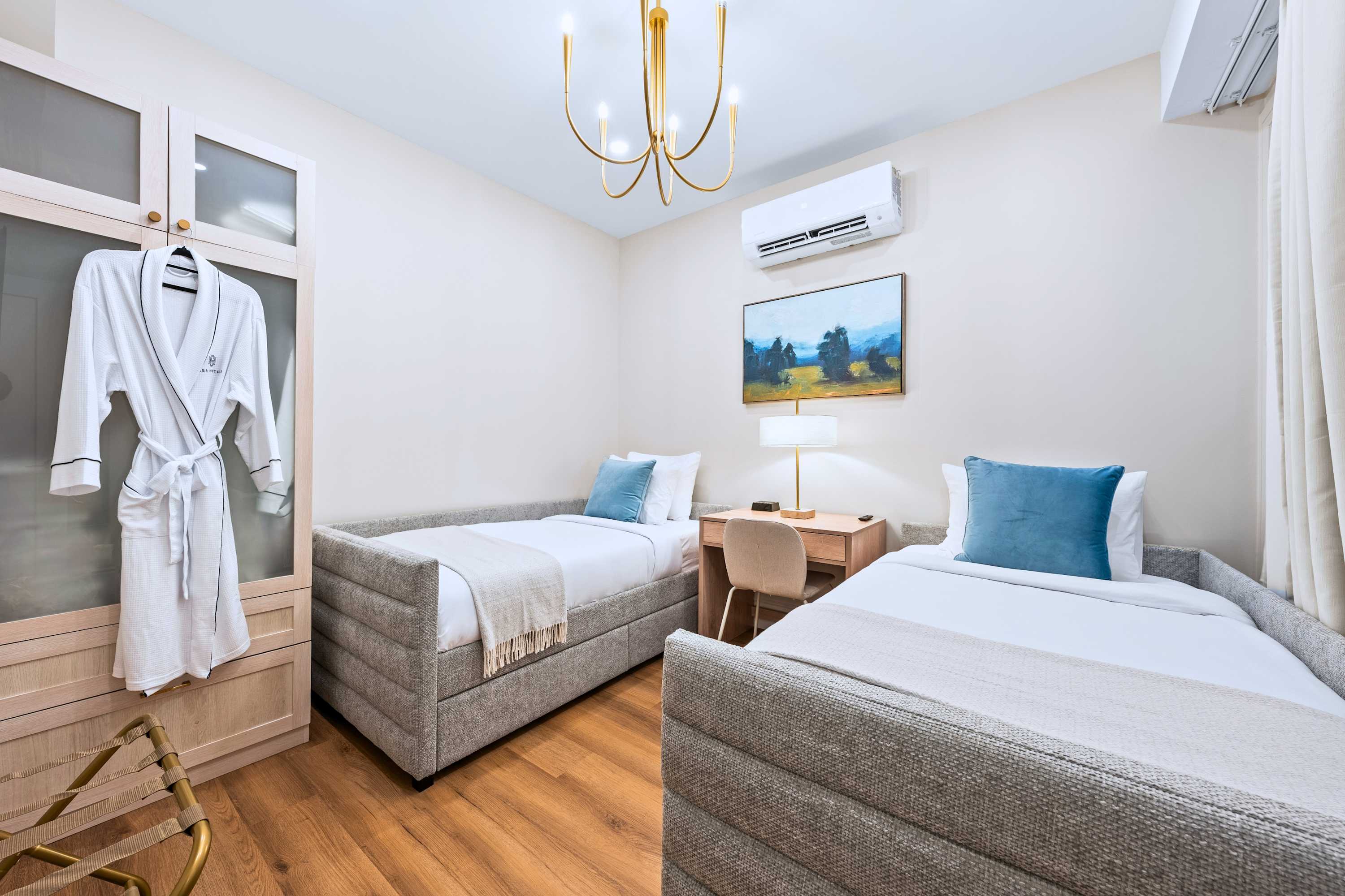 Bedroom with two single beds and hotel quality robes, set for a relaxed, easy stay