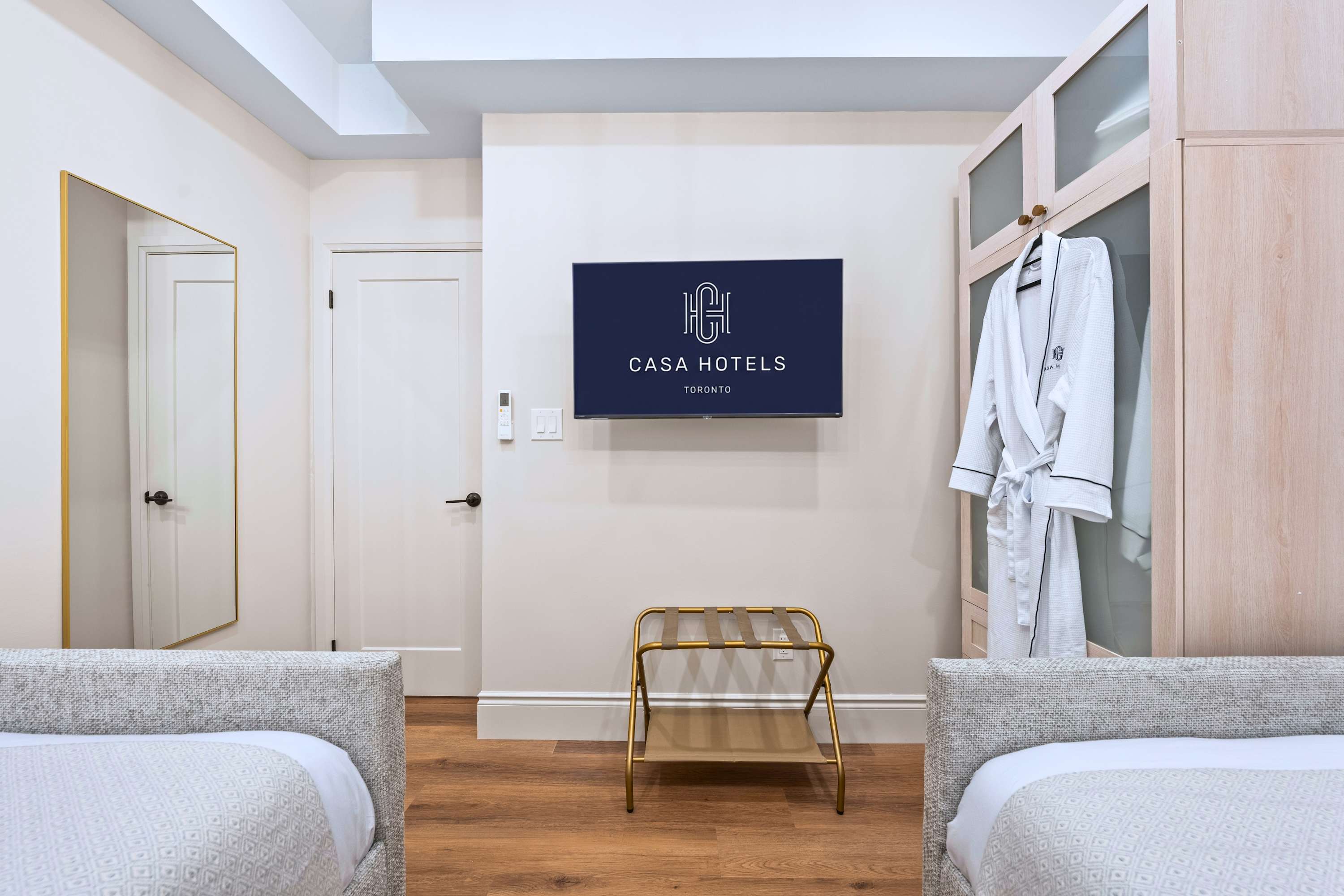 Bedroom with two single beds, smart TV, robes, and cabinet for comfort and convenience