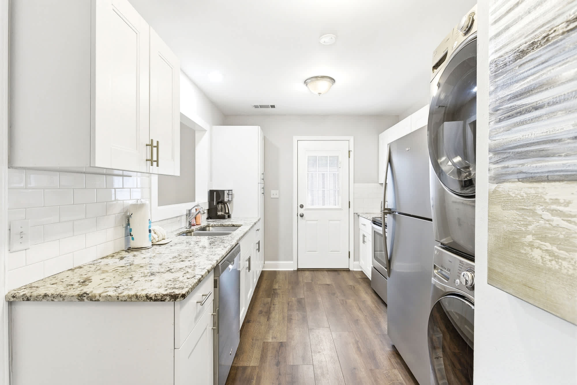 White shaker cabinets, granite countertops, subway tile backsplash, and stainless appliances make this kitchen as functional as it is fresh.