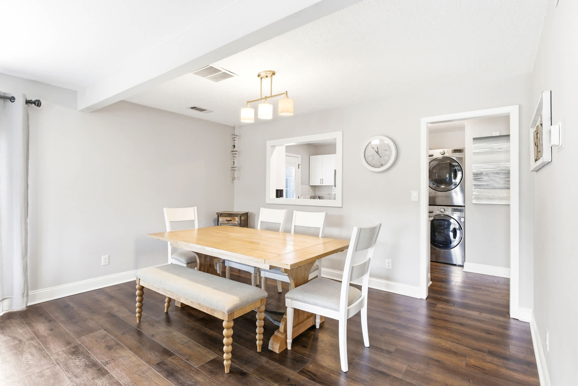 Gold pendant light, a farmhouse table with bench seating, and easy access to the kitchen make this dining room ready for every meal.