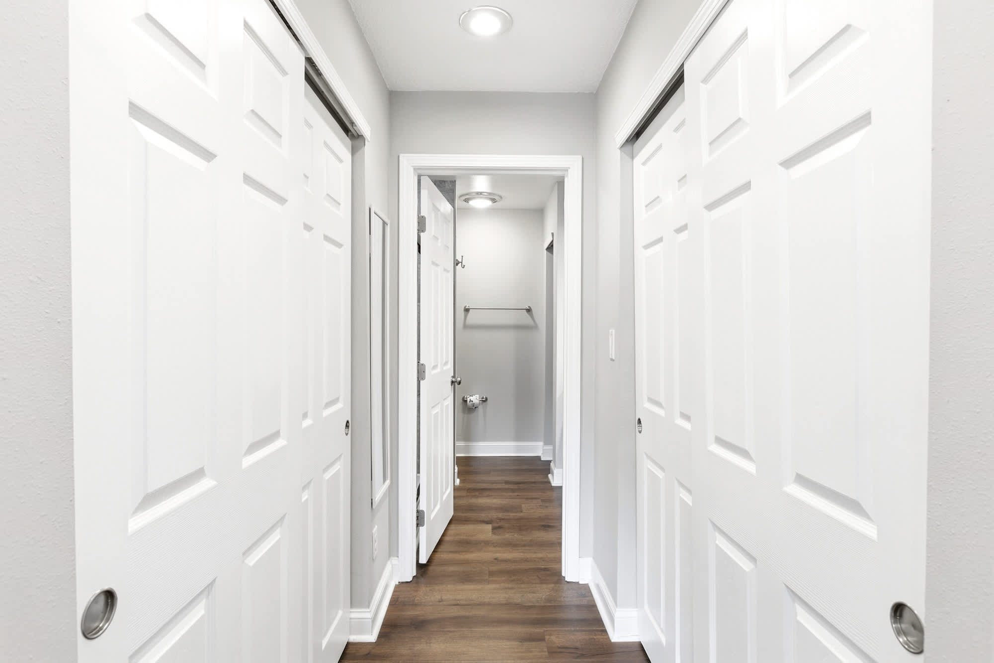 Dual sliding closet doors line the private hallway leading to the primary en suite — plenty of space for a full week's wardrobe.