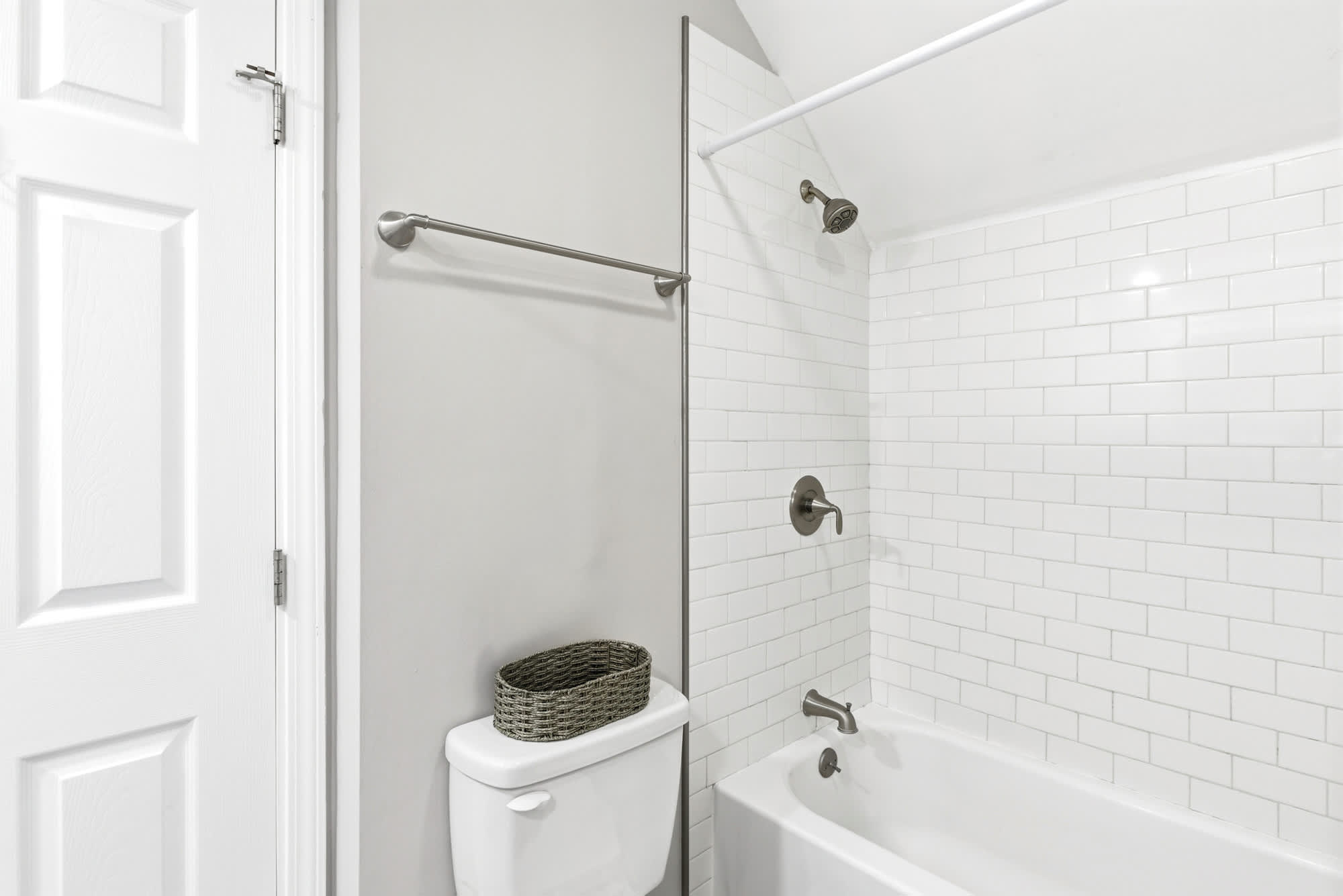 Bright guest bath with crisp white subway tile tub/shower combo and brushed nickel fixtures — simple, stylish, and spotless.