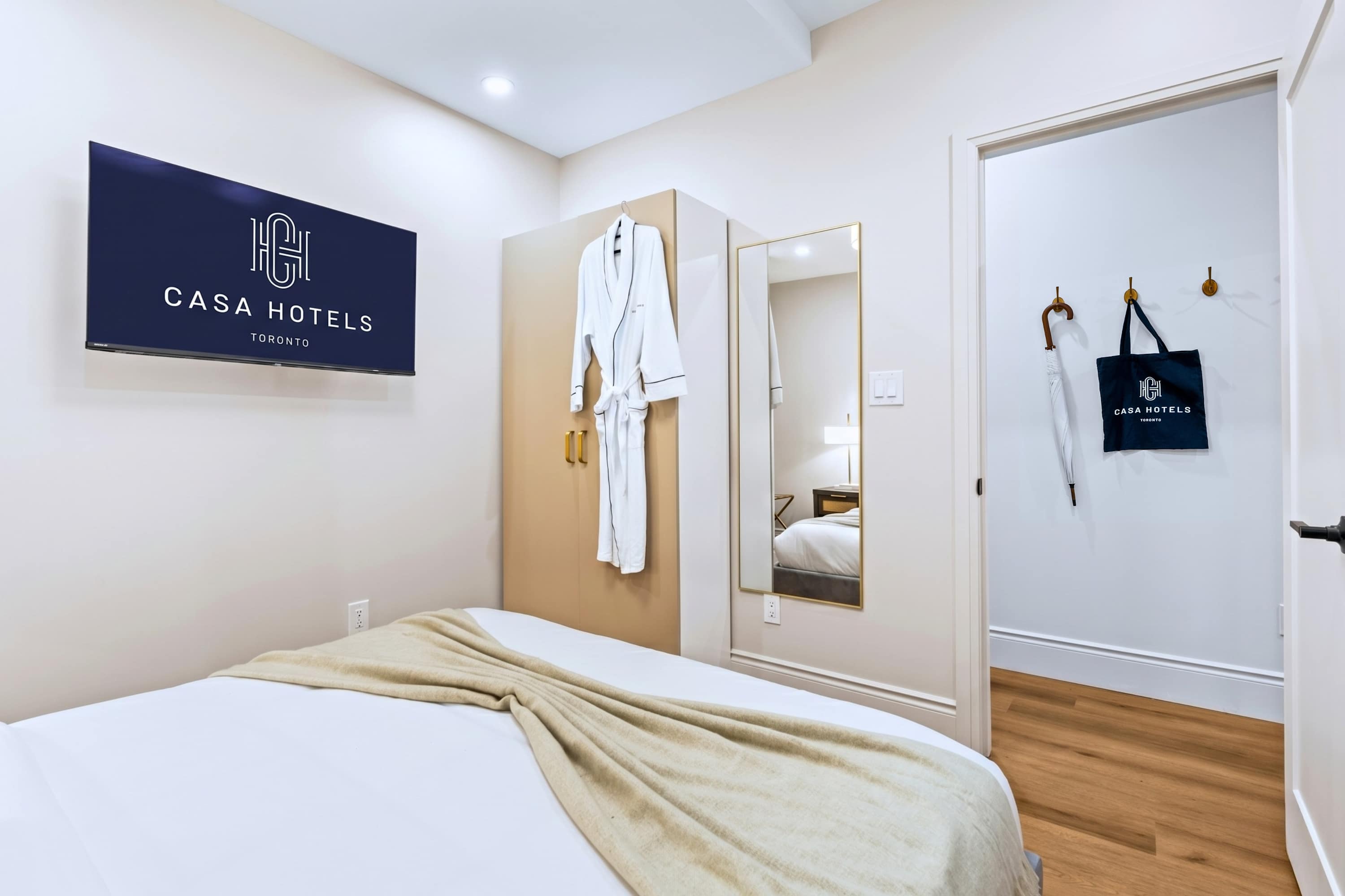 Queen bed with premium bedding, private screen, and hotel robe for slow, comfortable evenings