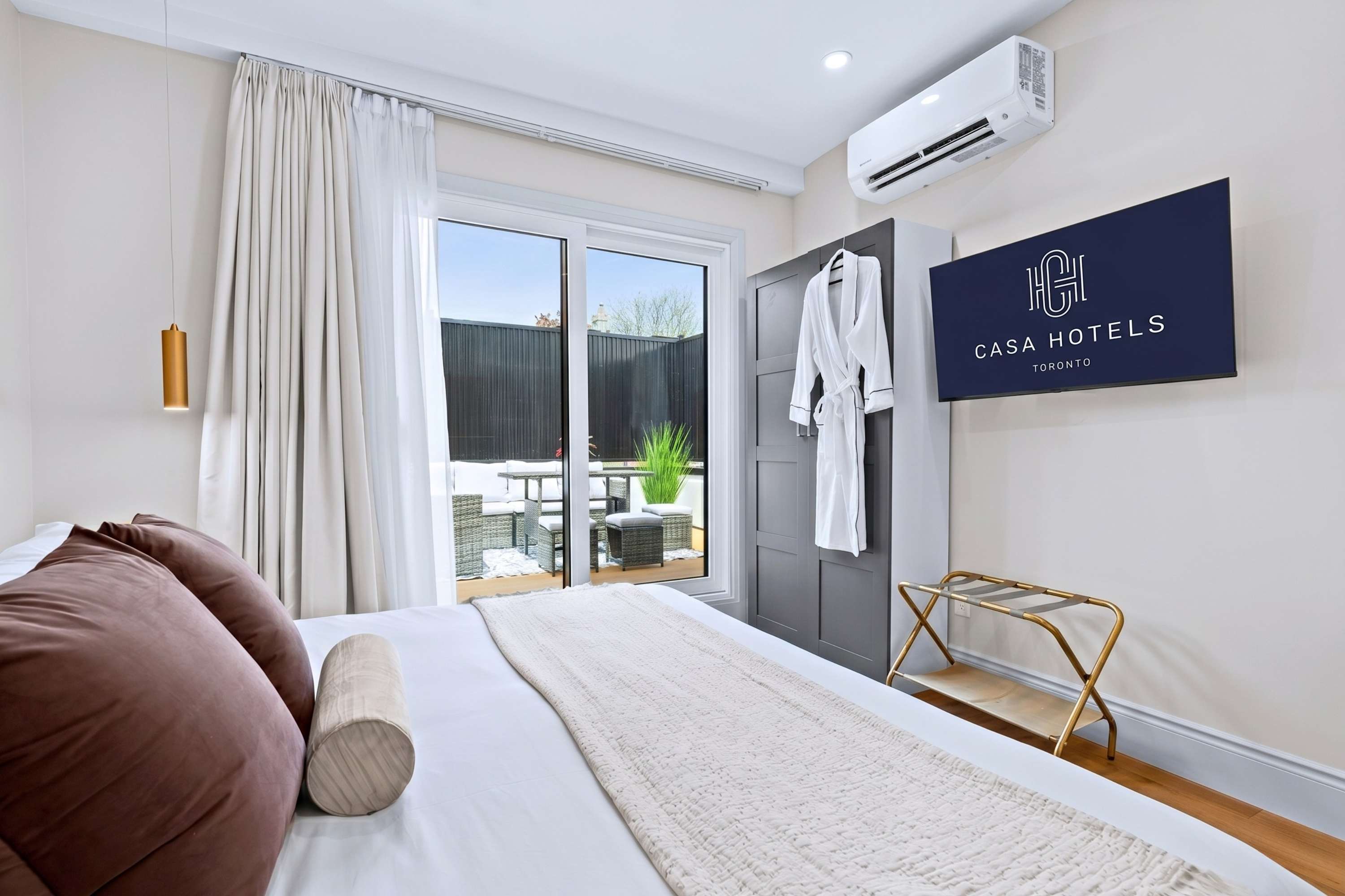 Queen bedroom with TV, robe, and a private patio for relaxed downtime