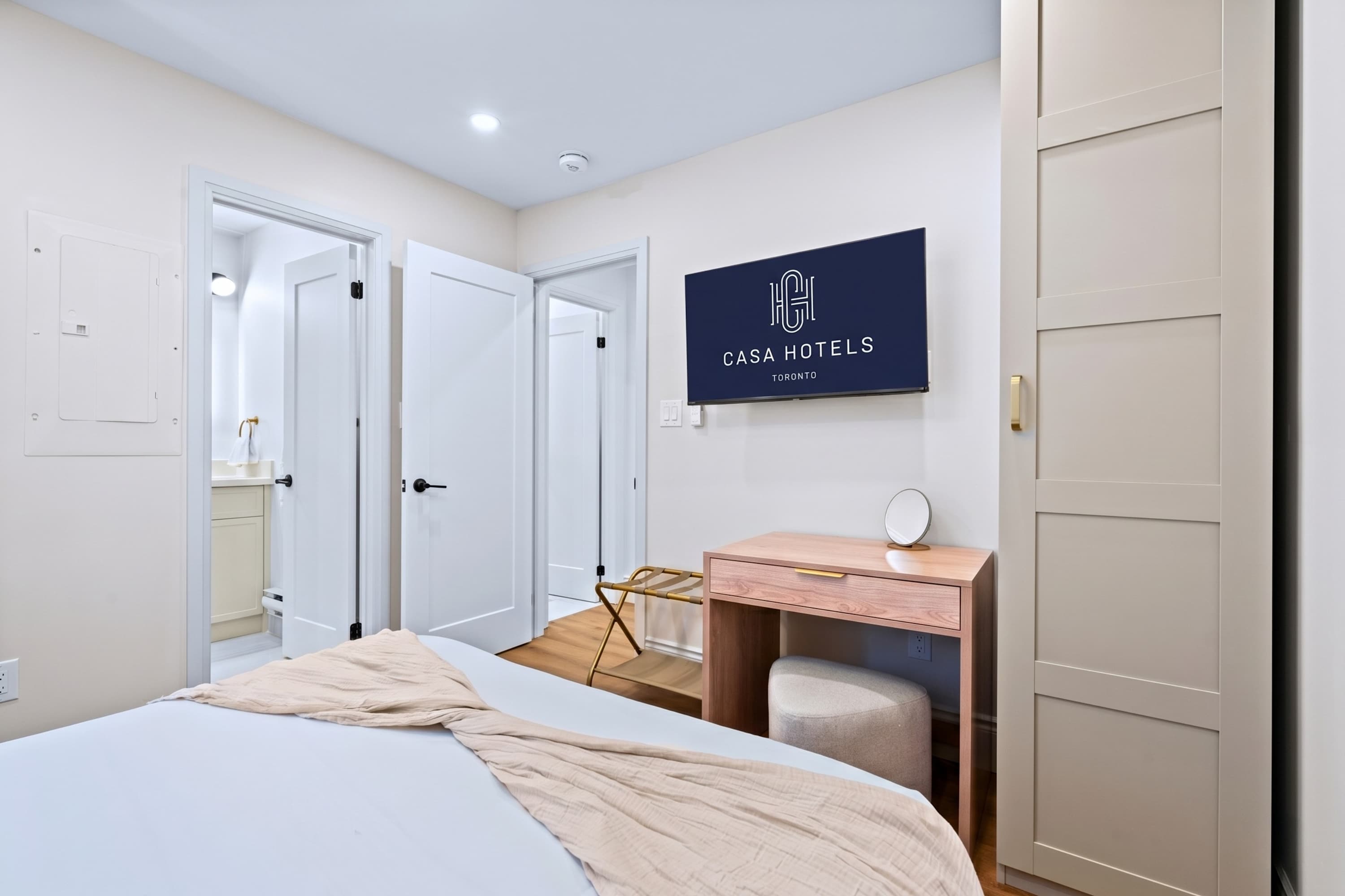 Queen bedroom with Smart TV, robes, and easy bathroom access for comfort and convenience