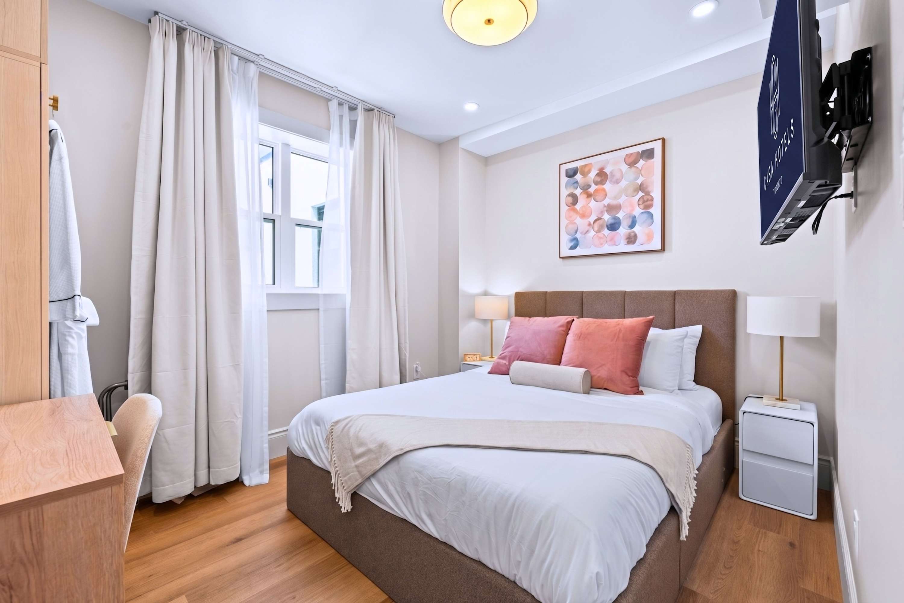 Bright sleeping space with guest-ready linens and bathrobe.