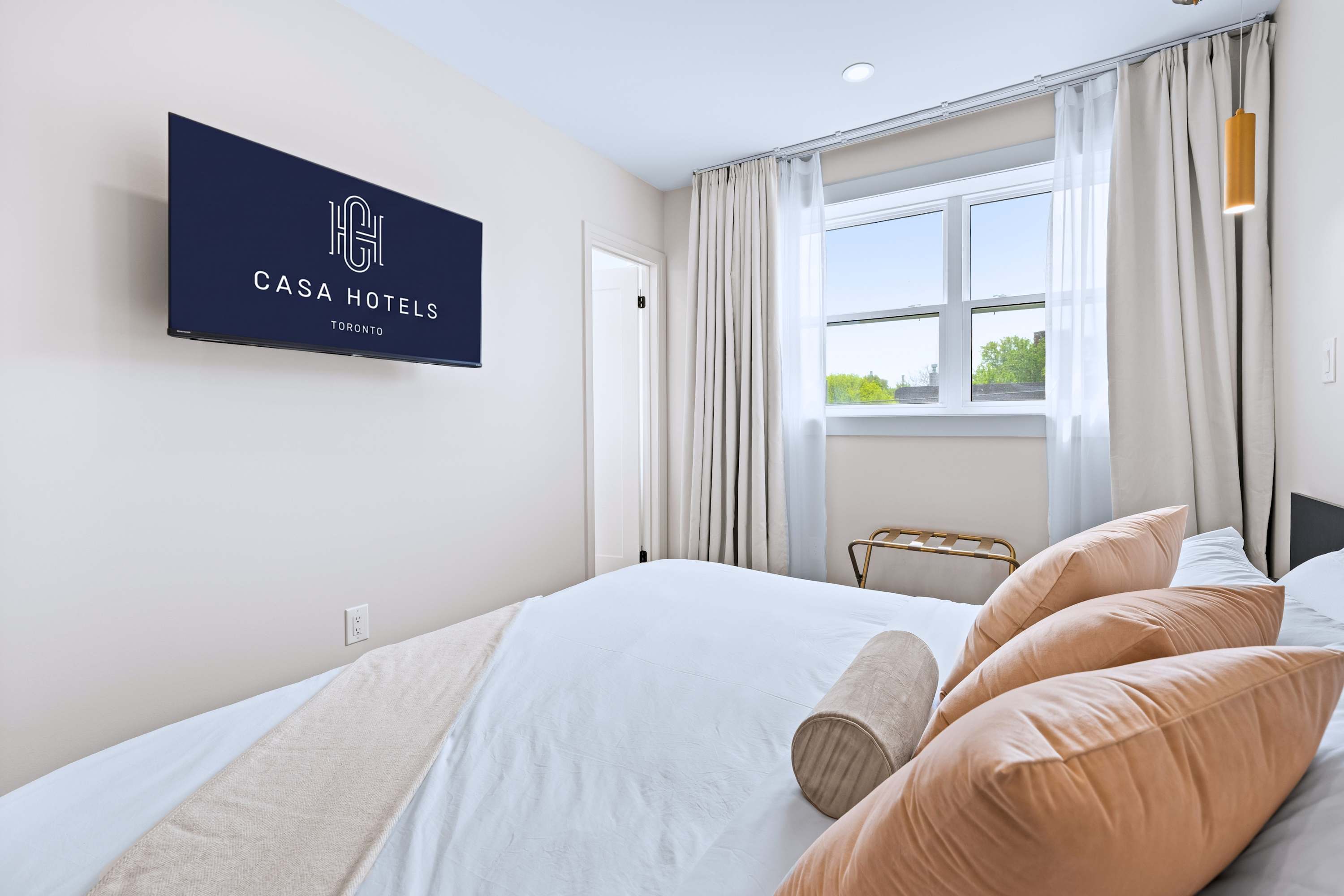 Simple, inviting space with soft bedding and Smart TV.