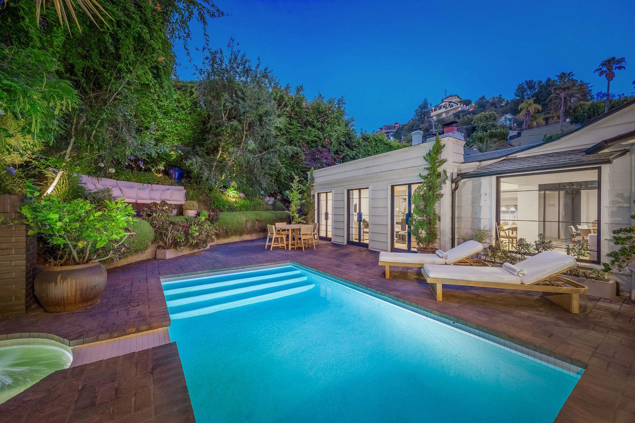 Make yourself at home beside the pool, surrounded by lush landscaping and glowing evening light.