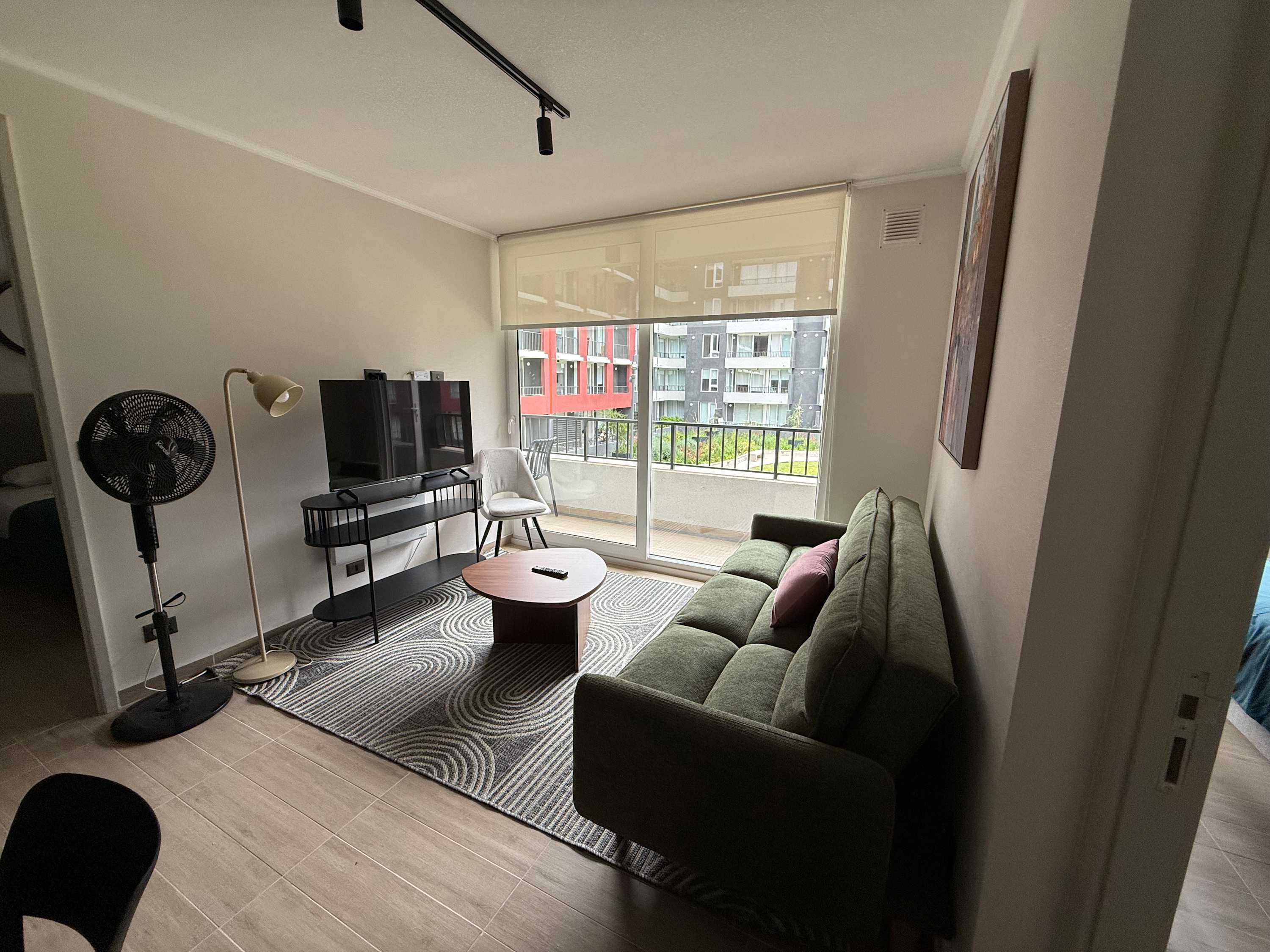 Relax in this cozy living room with a comfy sofa and a view from the balcony, perfect for unwinding after a day of exploring.