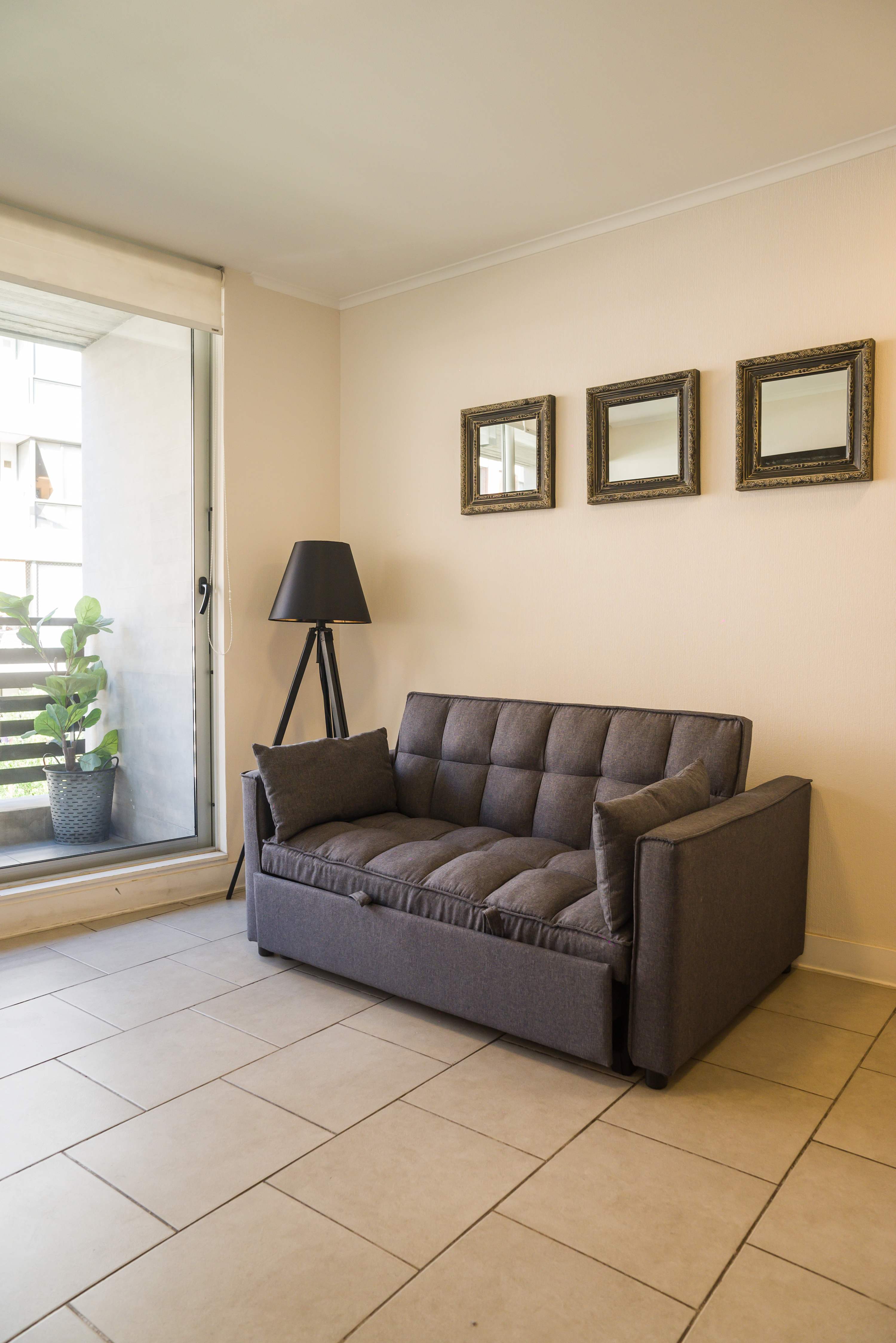 Relax in this cozy living area with a plush sofa and natural light from the large window, perfect for unwinding after a day of exploring.