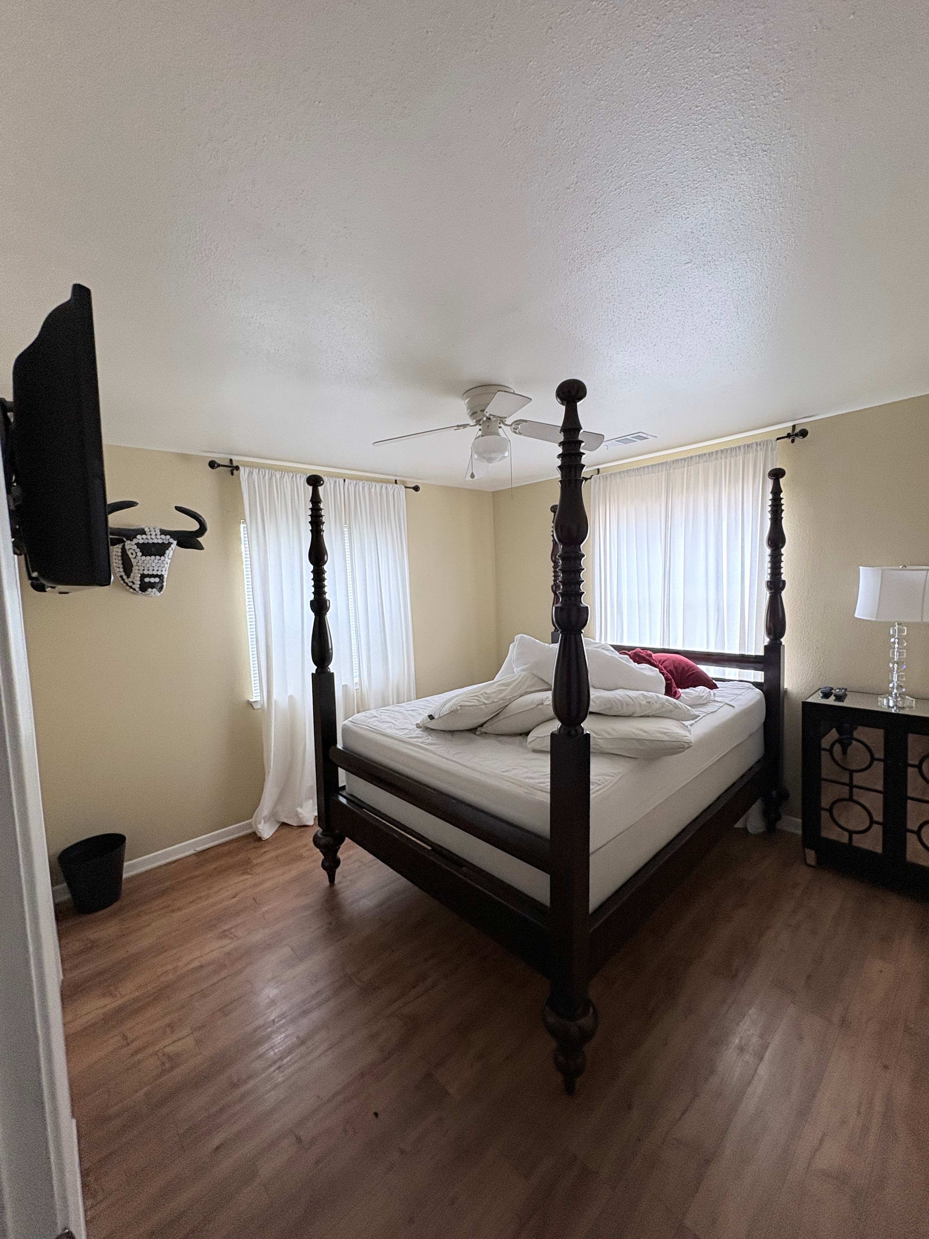 Cozy bedroom with a four-poster bed and natural light, perfect for a relaxing stay.