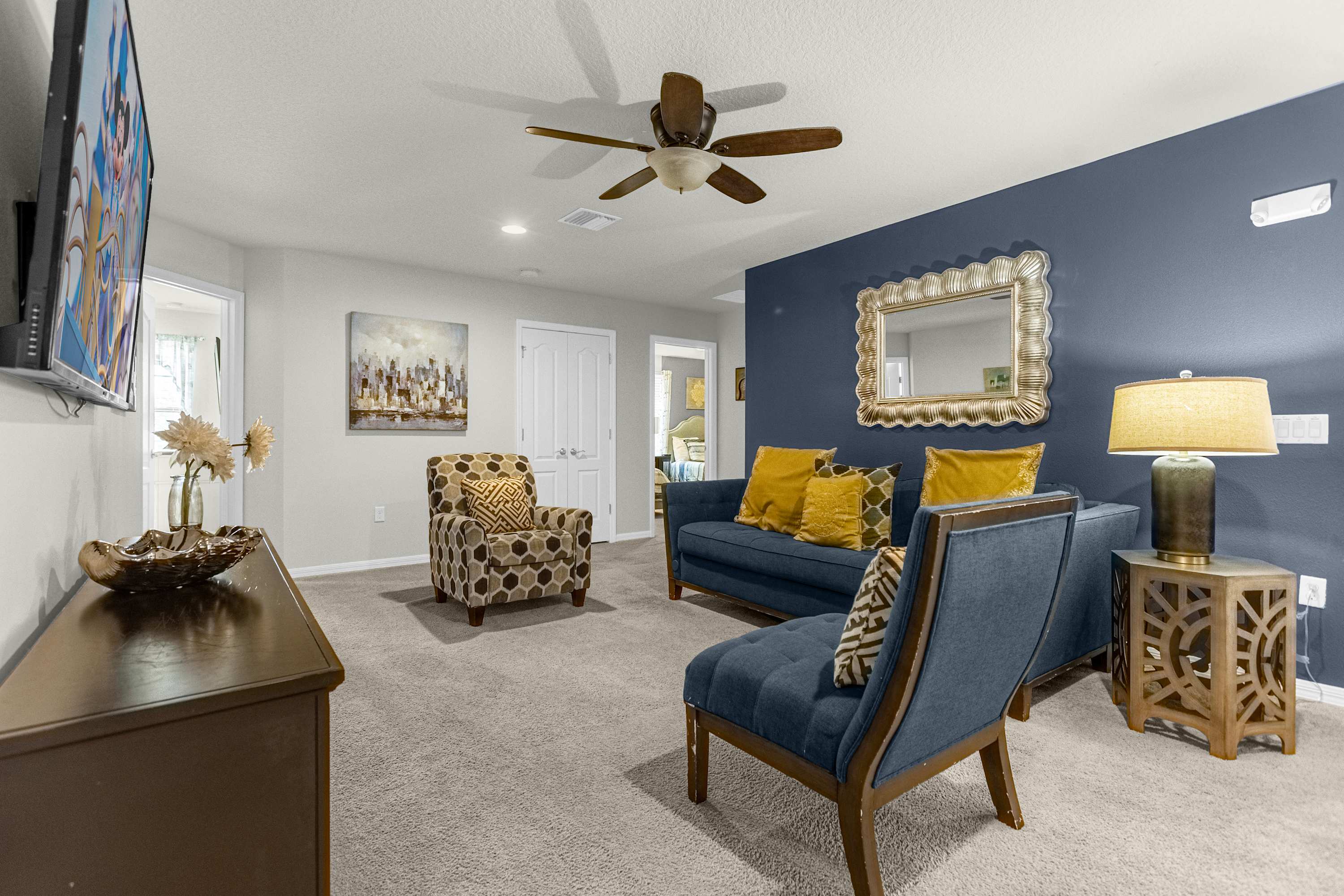 Relax in this cozy living room with plush seating, vibrant decor, and a flat-screen TV for ultimate comfort.