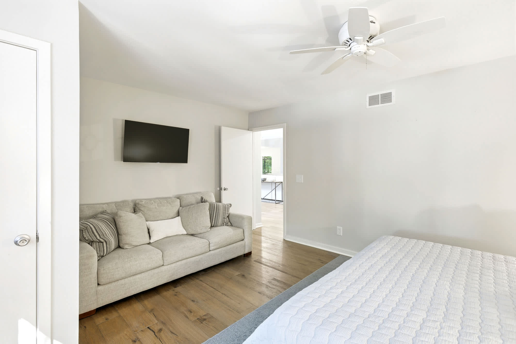 This king bedroom features a private sofa sitting area with wall-mounted TV — the perfect hideaway for guests who want their own space.