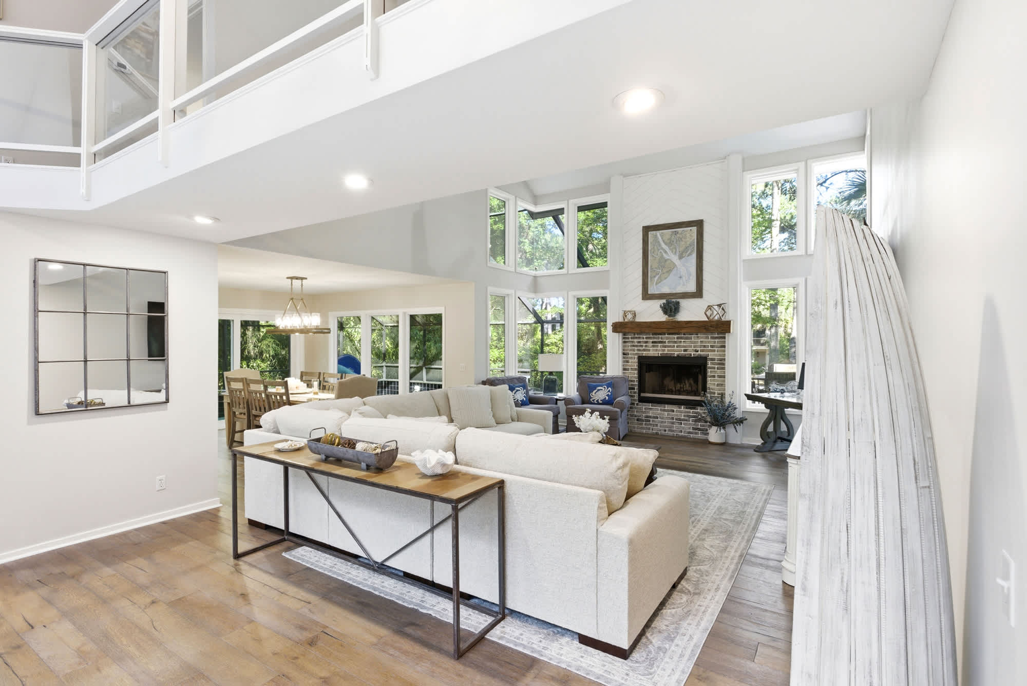 The living room's shiplap fireplace wall anchors the entire open floor plan, visible from the dining area and kitchen with easy indoor-outdoor flow.