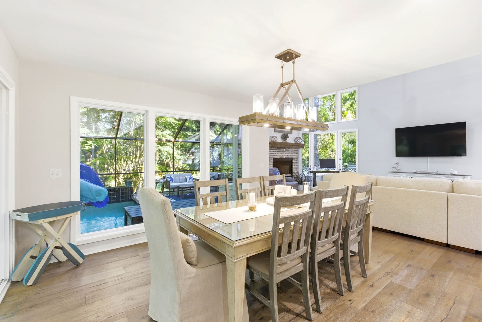 A warm, sun-filled dining room with seating for eight, a gold pendant light, and a 'the fondest memories are made gathered around the table' sign that says it all.