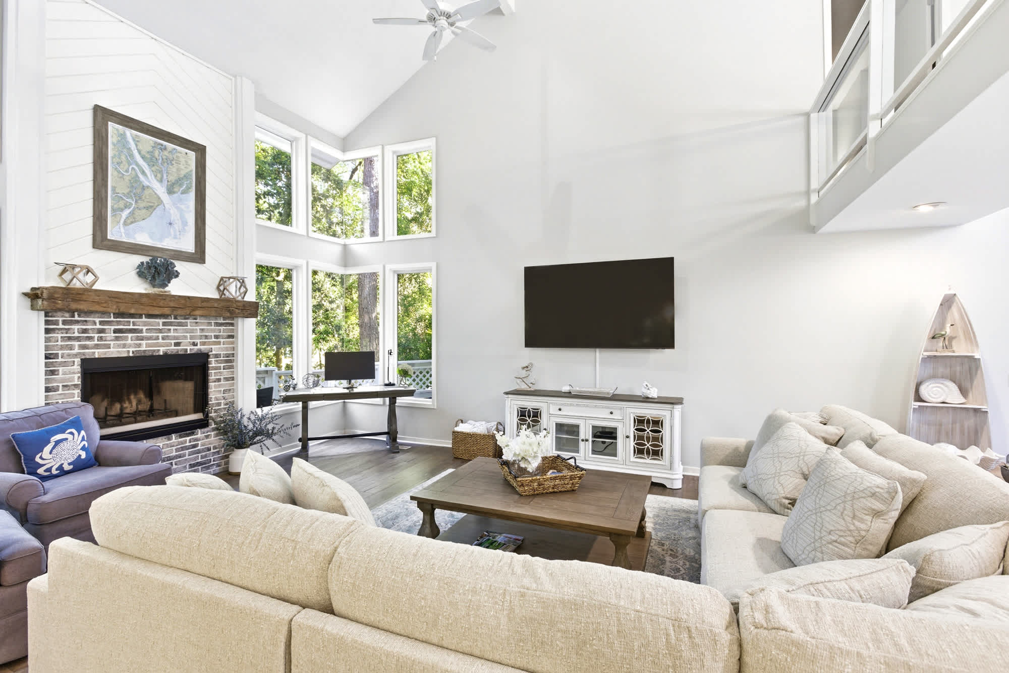 The oversized sectional, shiplap fireplace, rustic TV console, and decorative wooden boat bookshelf make this living room impossible to leave.