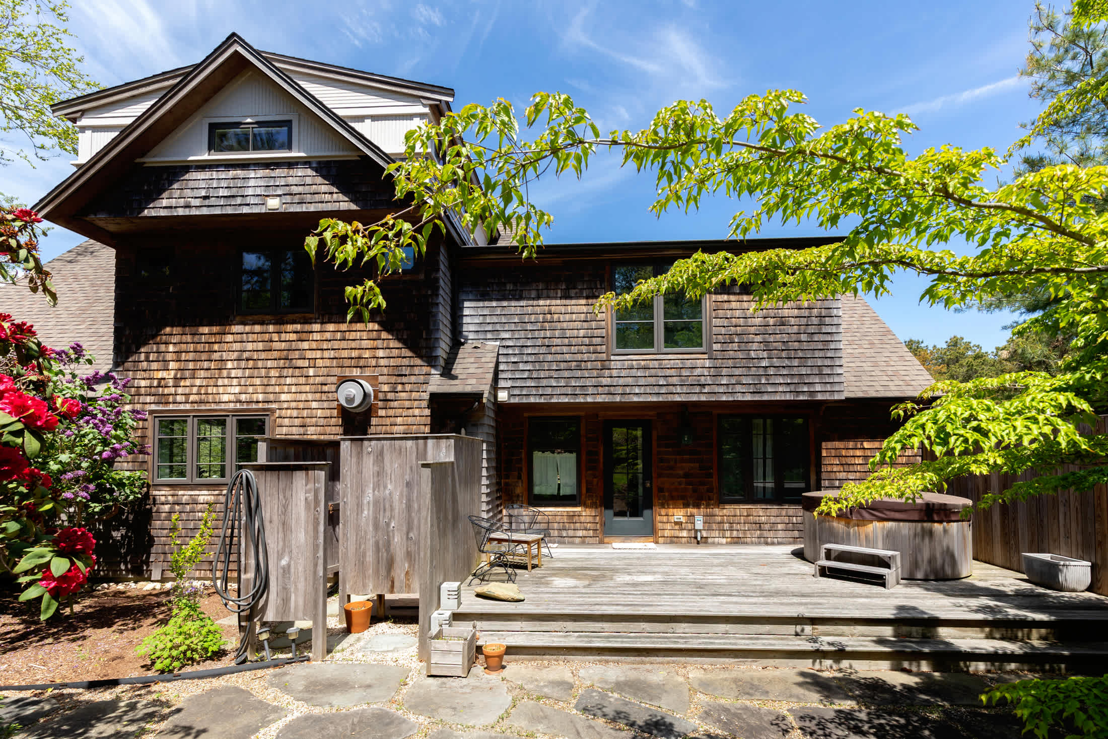 A private hot tub, outdoor shower, and deck seating create a relaxing Cape Cod retreat after beach days.