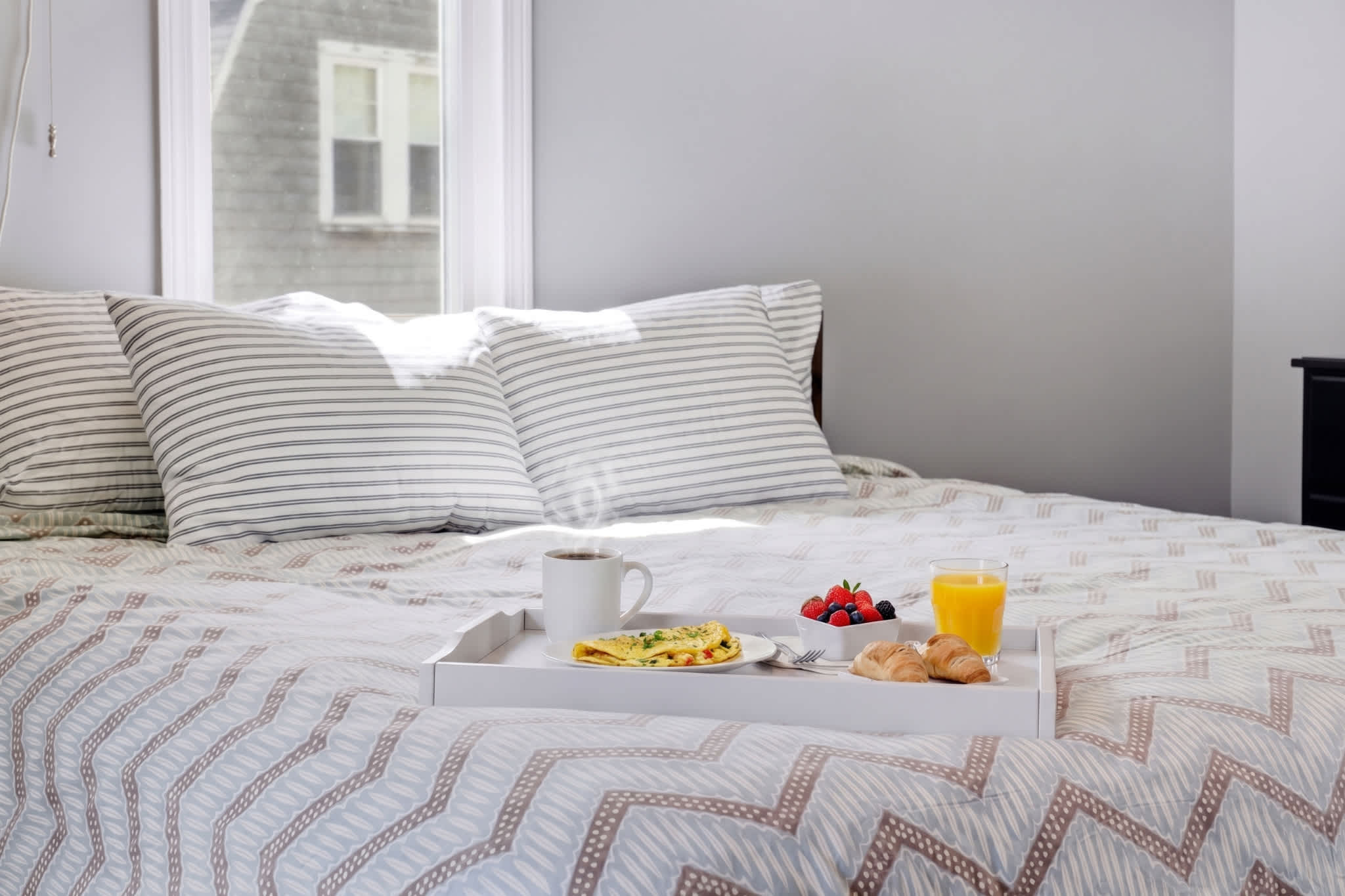 The primary bedroom boasts a plush king bed & smart TV​