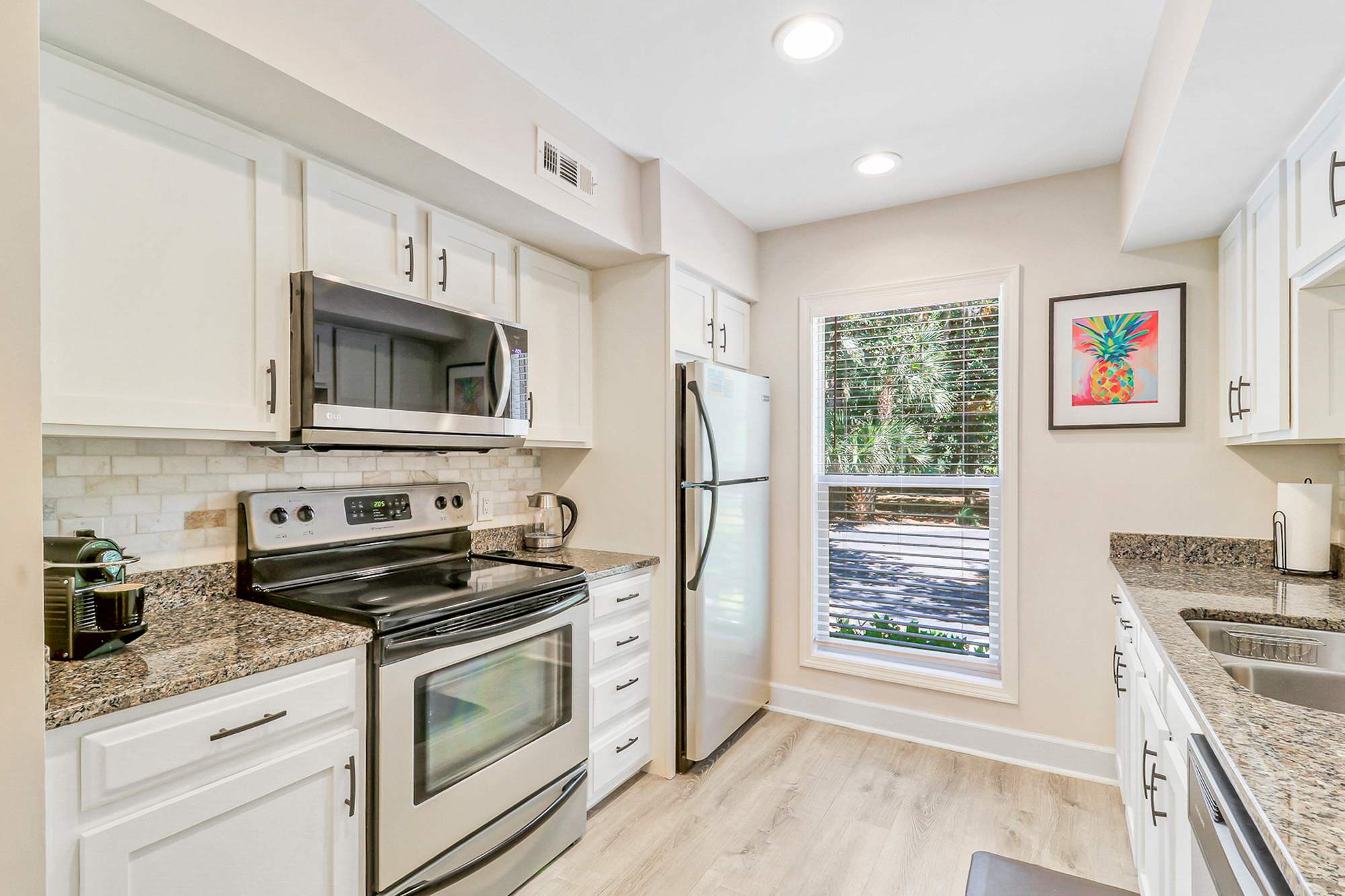 Everything guests need including a Nespresso machine, full stainless appliance suite, and ample counter space. Natural light from the garden window makes mornings feel easy and bright.