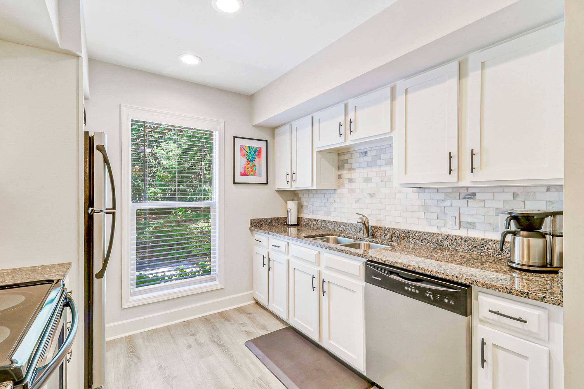 Clean up is a breeze with a deep stainless sink, dishwasher, and plenty of counter space. The garden window above the sink overlooks lush greenery for a pleasant backdrop.