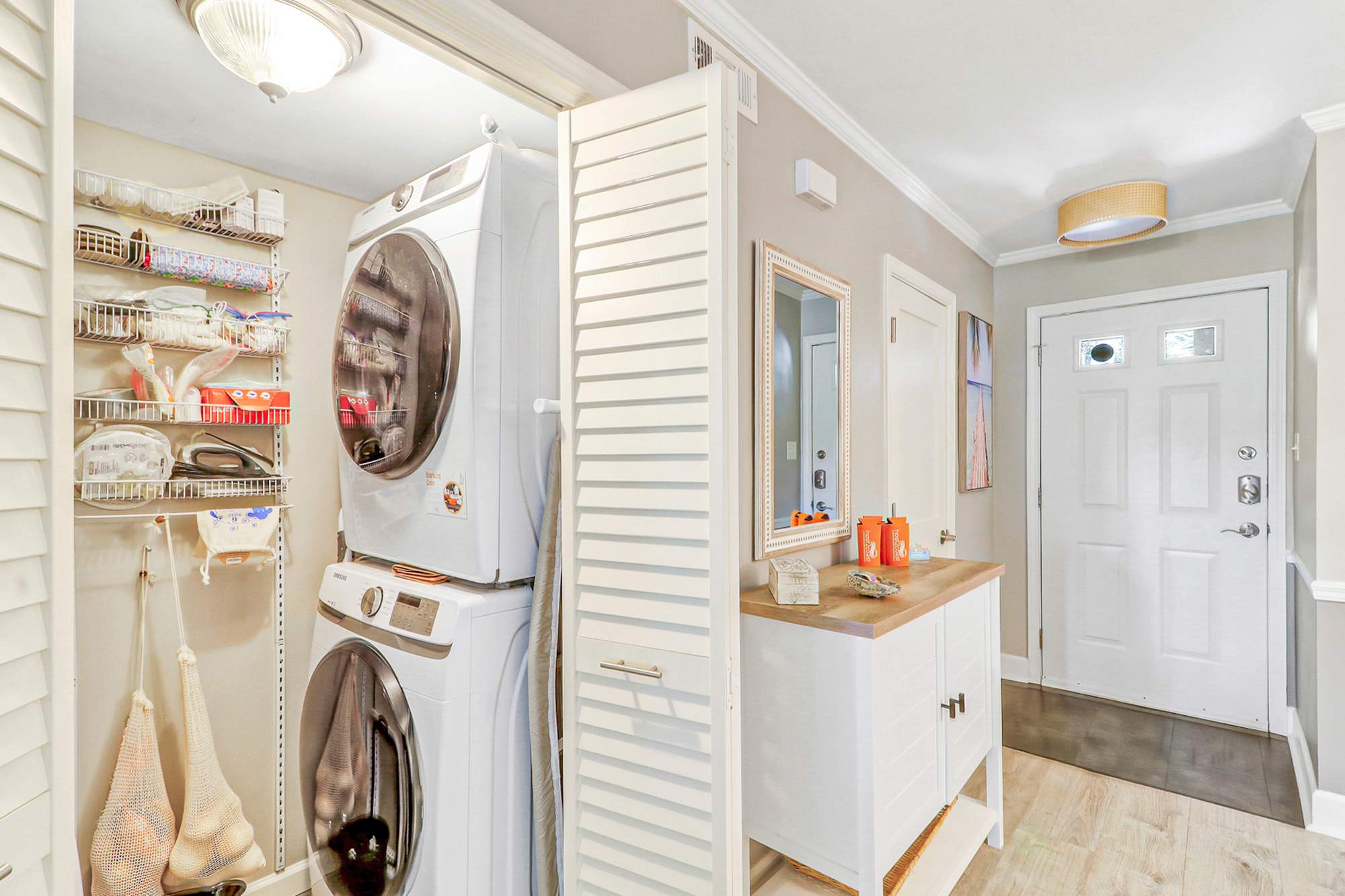 Full-size stacked washer and dryer tucked conveniently off the entry. Guests on longer stays can pack lighter knowing laundry is always an option, with extra supplies on the utility shelf.