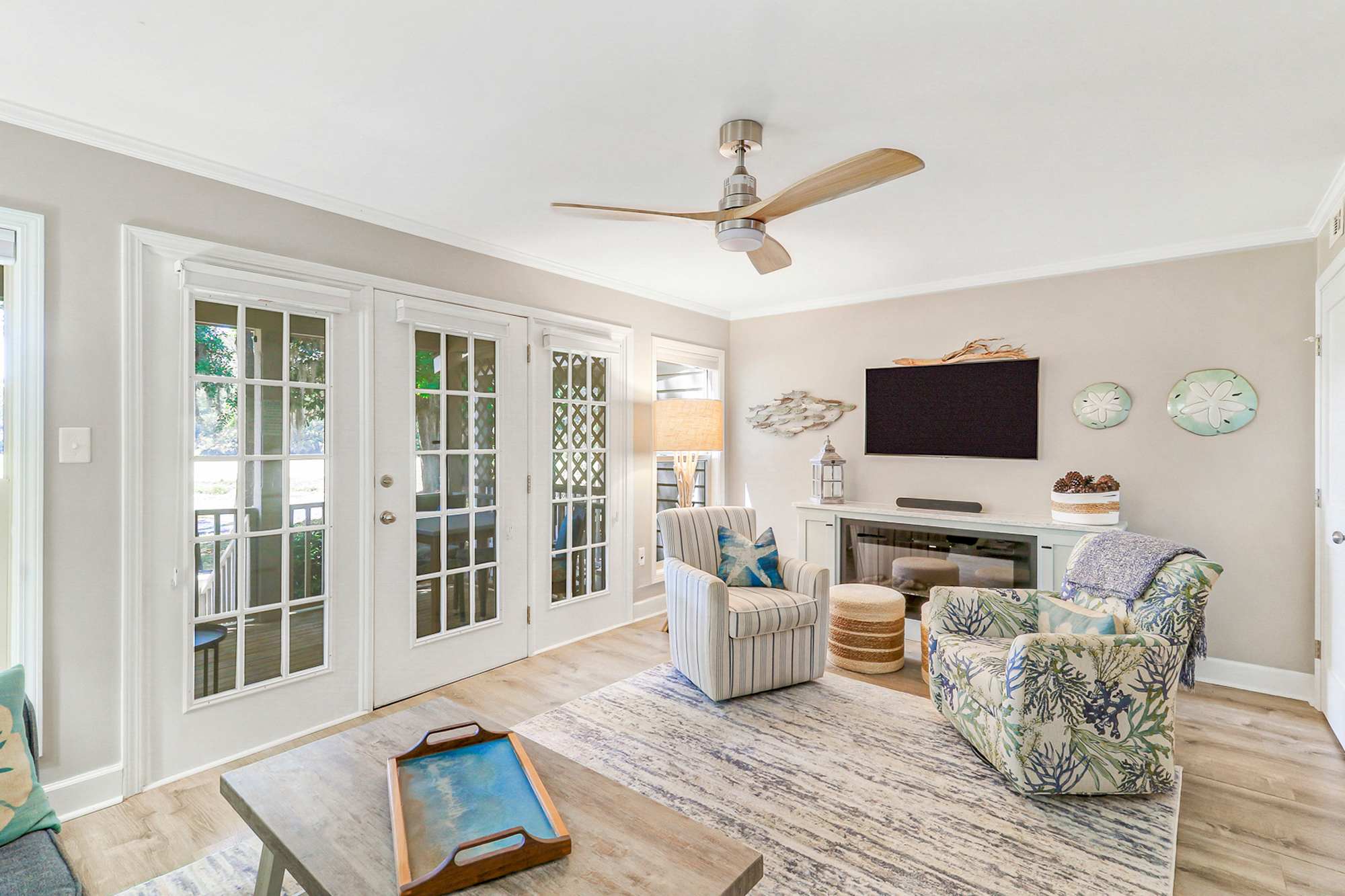 Relax with a movie or game on the flat-screen TV above the electric fireplace. The cozy seating, sand dollar accents, and French doors make this the heart of the home for guests.