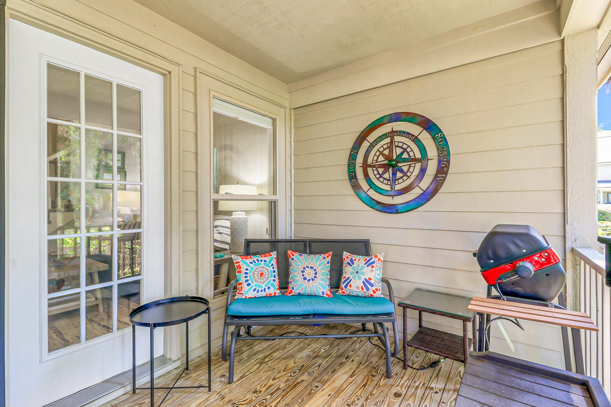 Fire up the gas grill and settle into the deck loveseat with a cold drink. This lounge area with compass rose art and colorful pillows is a guest favorite for unwinding after the beach.