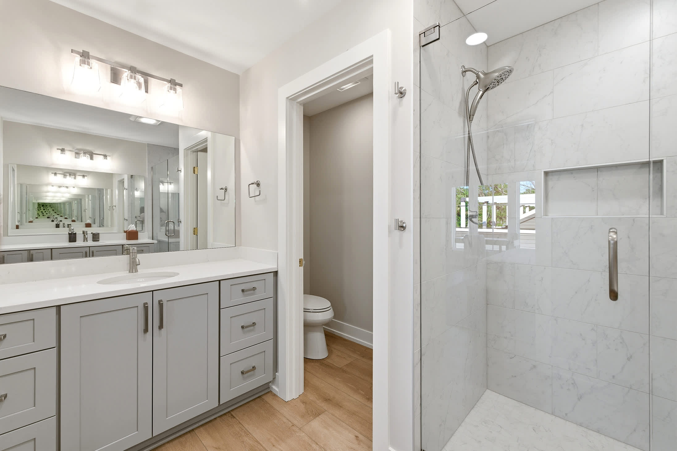 Marble shower, gray vanity, and a layout that thought of everything.